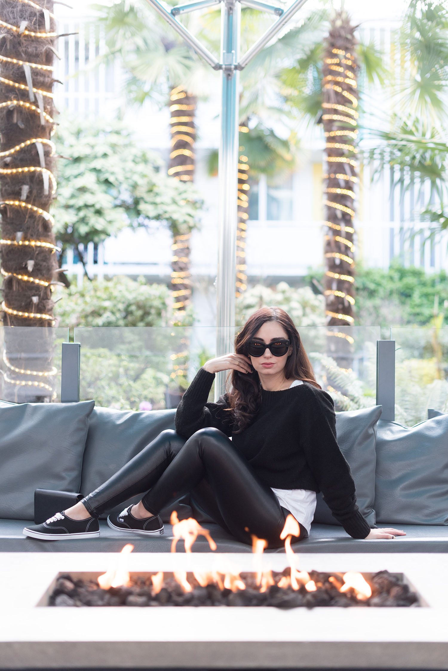Fashion blogger Cee Fardoe of Coco & Vera sits fire side at The Burrard Hotel wearing Aritzia leather leggings and Vans sneakers