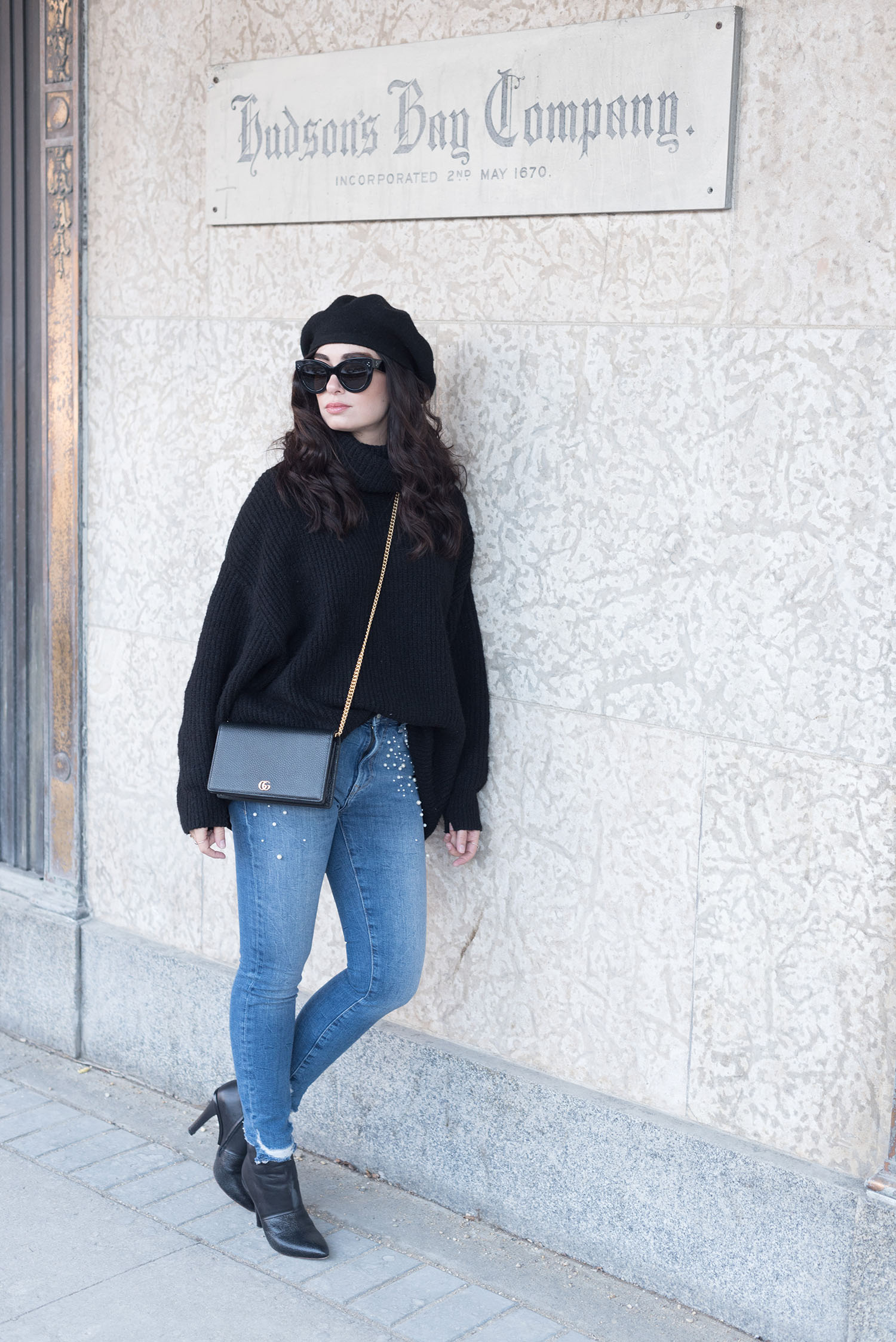 Fashion blogger Cee Fardoe of Coco & Vera stands outside the Bay Downtown in Winnipeg wearing Mavi pearl jeans and carrying a Gucci crossbody bag