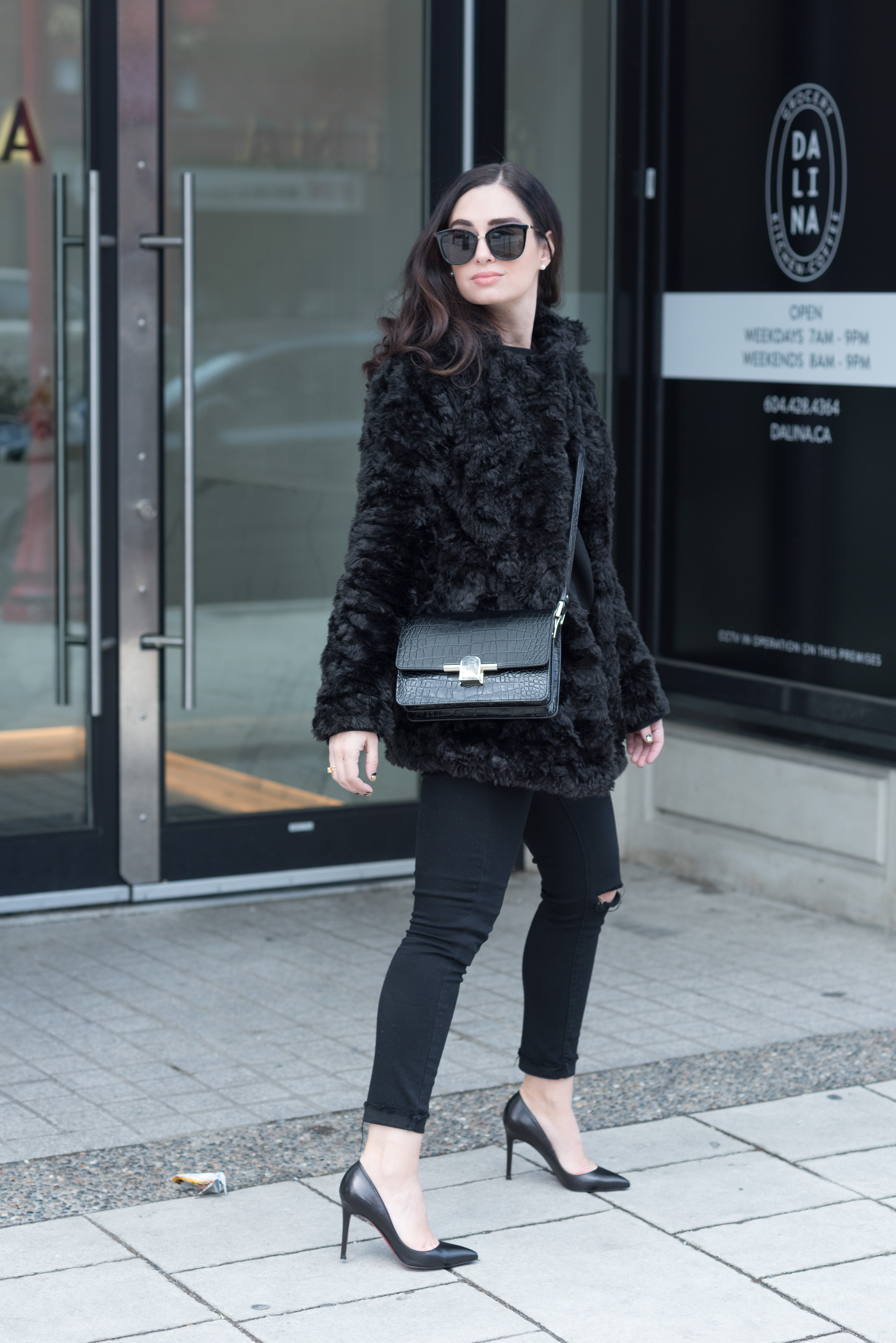 Fashion blogger Cee Fardoe of Coco & Vera stands outside Dalina in Vancouver wearing a black fur coat from Le Chateau and Le Specs sunglasses