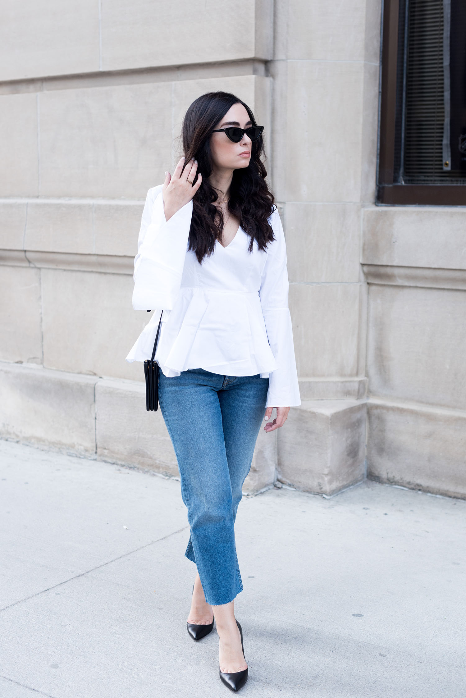 Canadian fashion blogger Cee Fardoe of Coco & Vera walks in the Exchange District in Winnipeg wearing Zara cat eye sunglasses and Grlfrnd Helena jeans