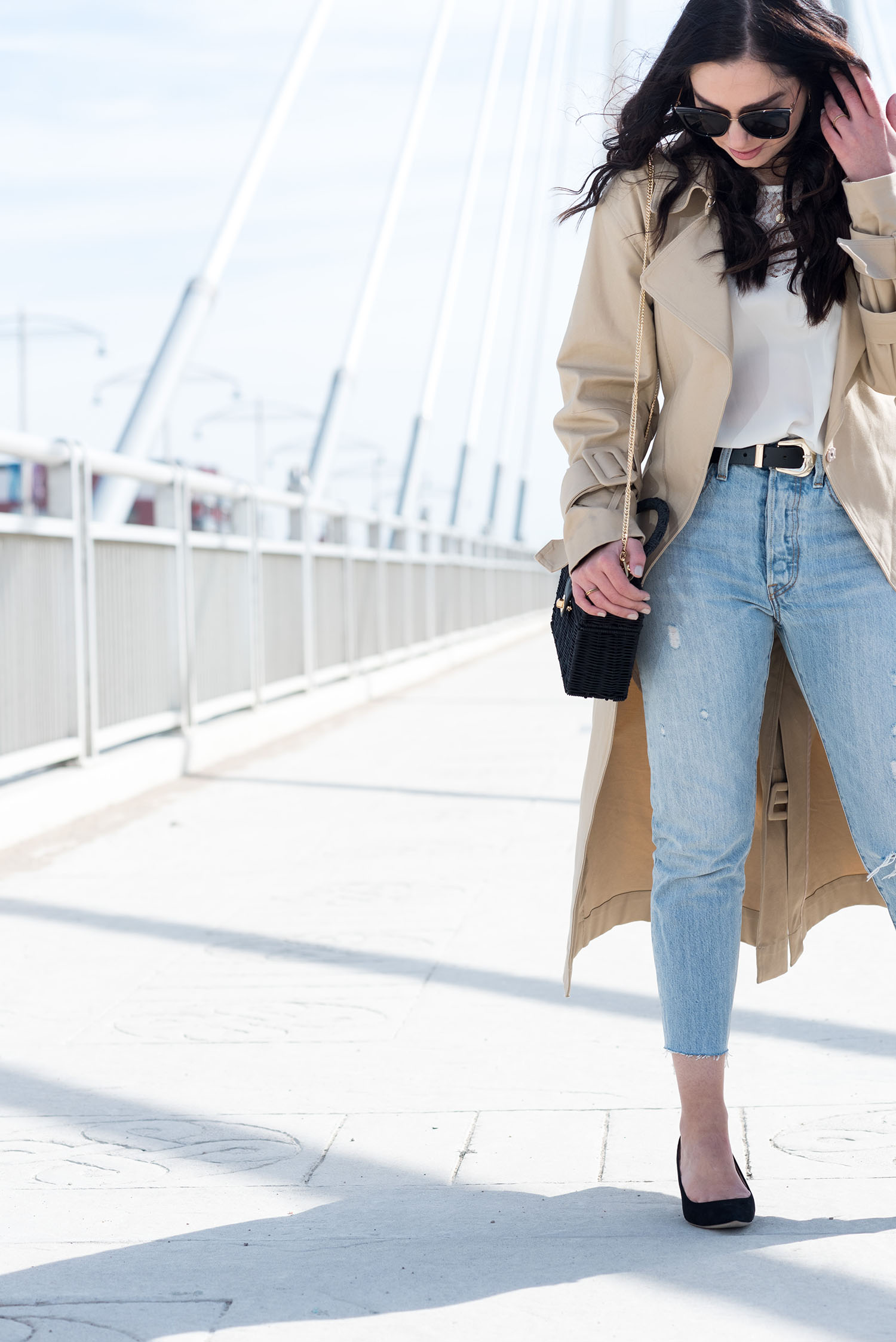 Winnipeg fashion blogger Cee Fardoe of Coco & Vera stands on Louis Riel bridge wearing Levi's 501 jeans and a Sezane silk blouse