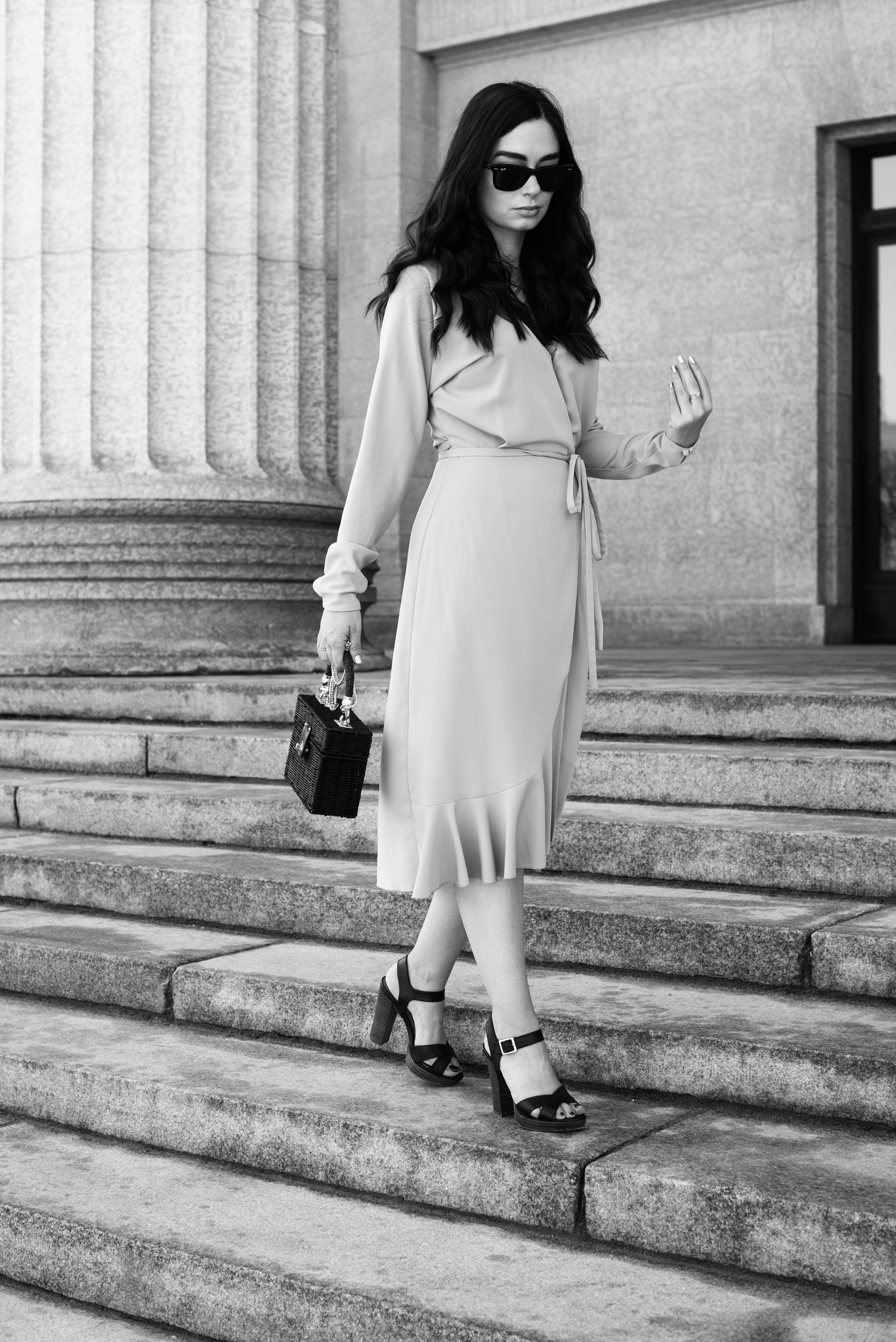 Top Winnipeg fashion blogger Cee Fardoe of Coco & Vera walks on the stairs of the Manitoba Legislature wearing an Aritzia dress and Le Chateau sandals
