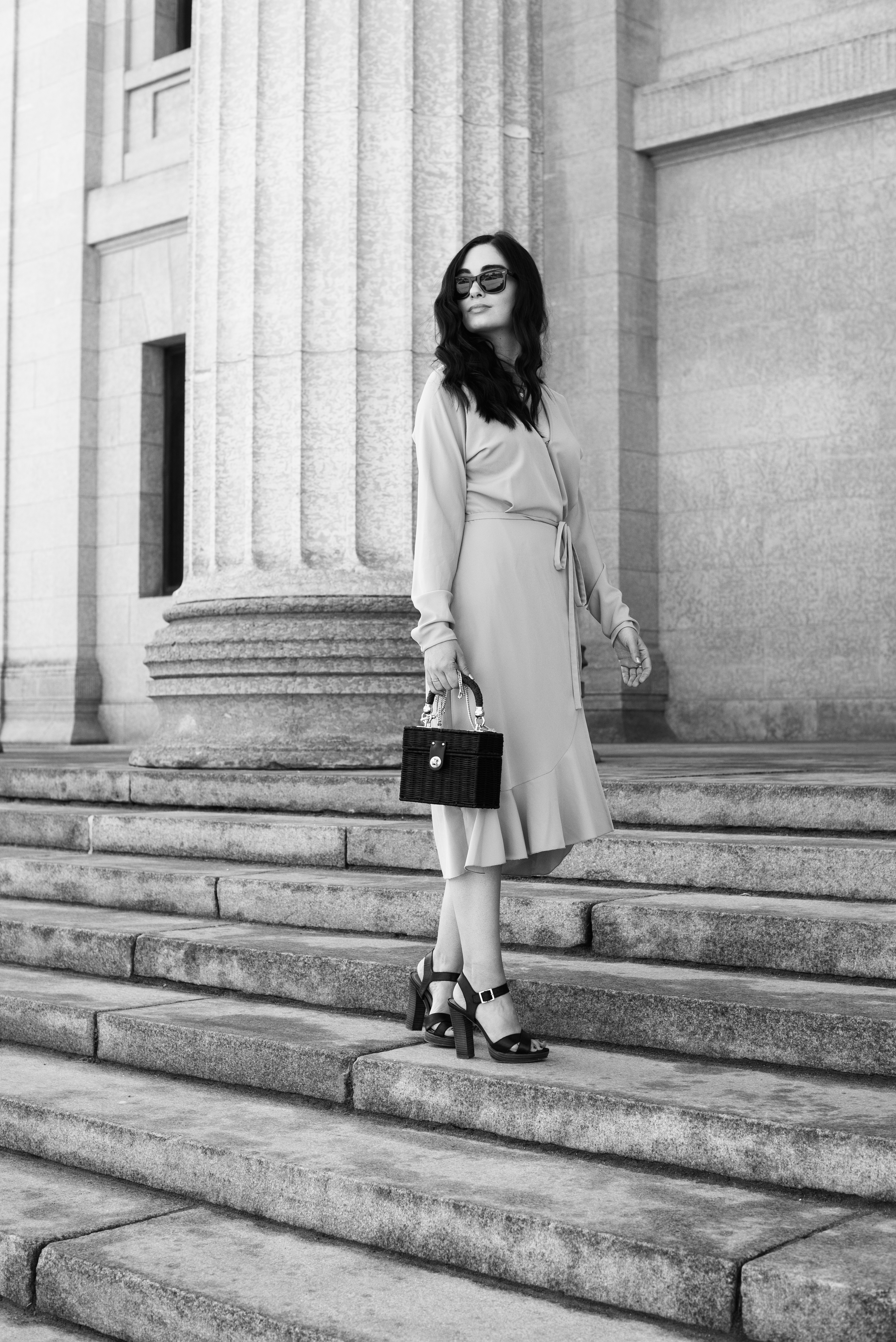 Top Winnipeg fashion blogger Cee Fardoe of Coco & Vera stands on the steps of Manitoba Legislature wearing a Wilfred wrap dress and carry Zara straw bag