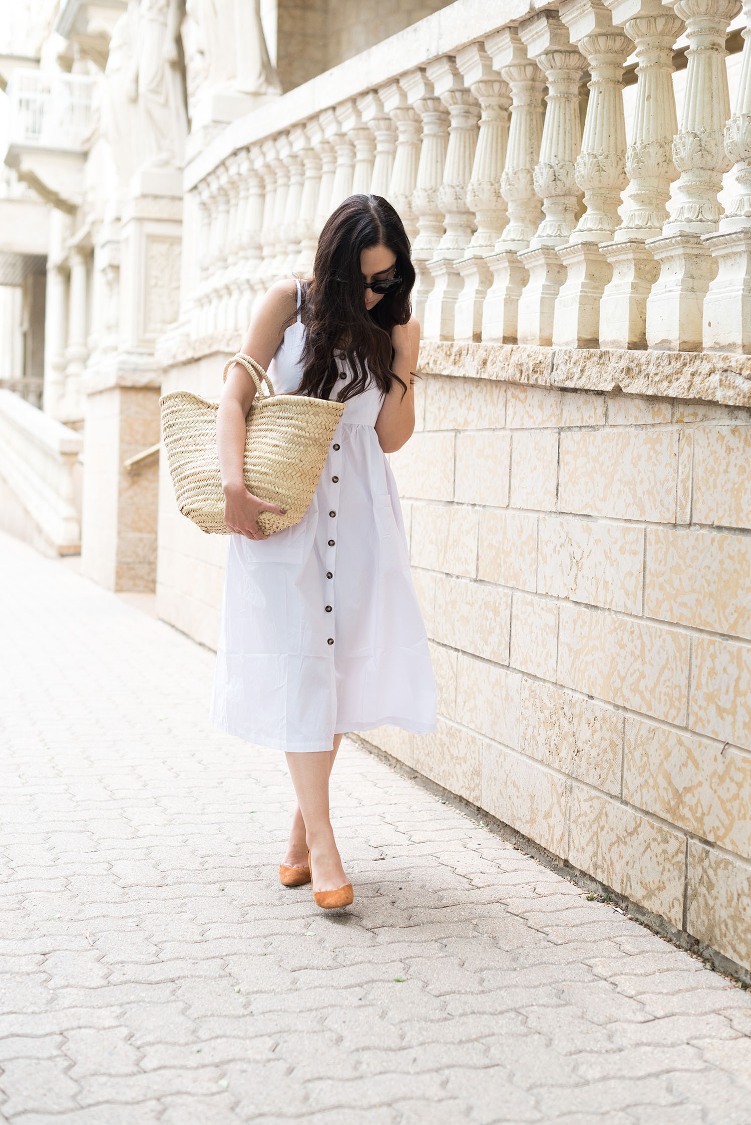 Top Winnipeg fashion blogger Cee Fardoe of Coco & Vera wears a white dress from Veni Dress and carries a Sezane straw tote bag
