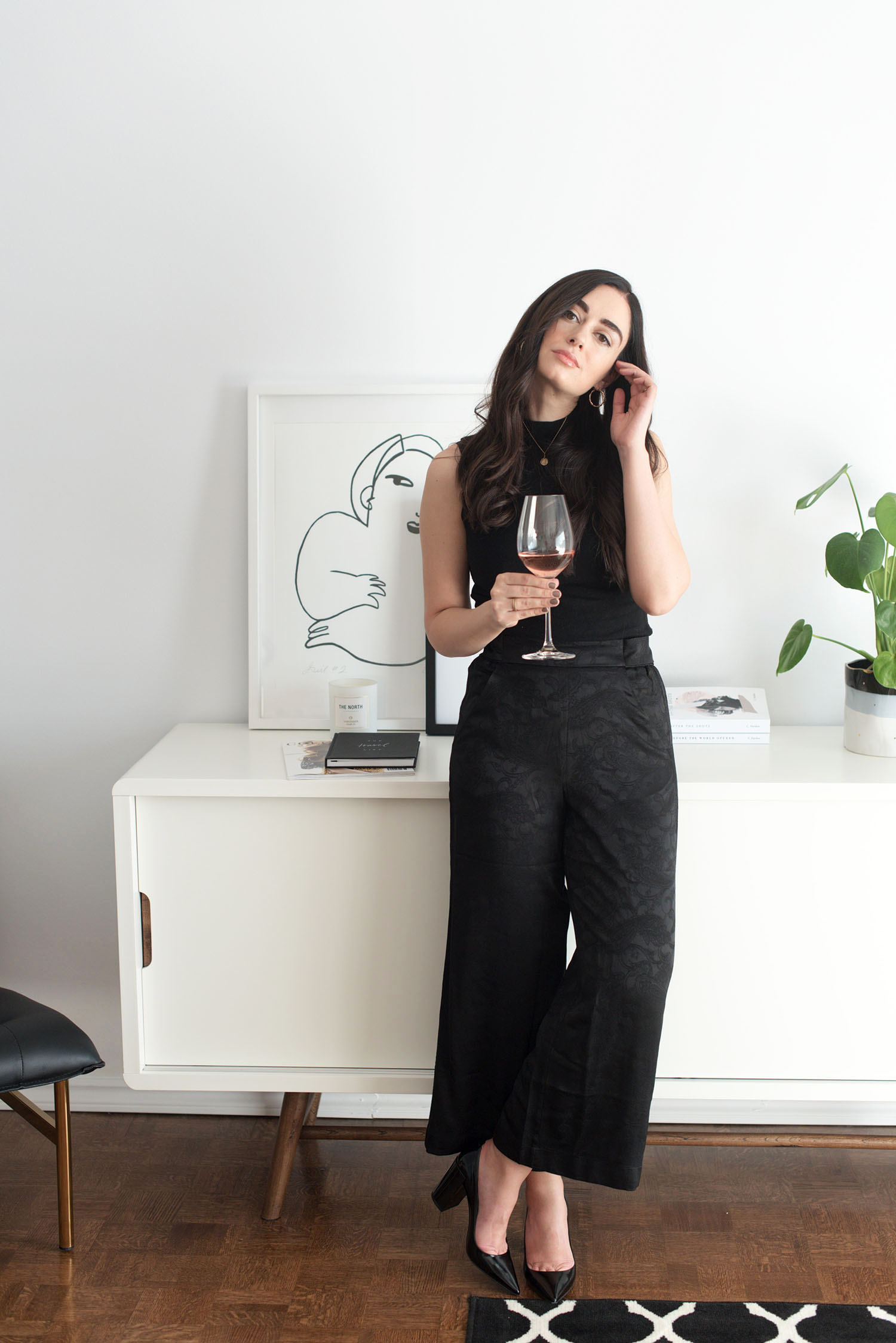 Top Winnipeg lifestyle blogger Cee Fardoe of Coco & Vera stands in her dining room wearing a black Aritzia culottes and Pierre Hardy block heels