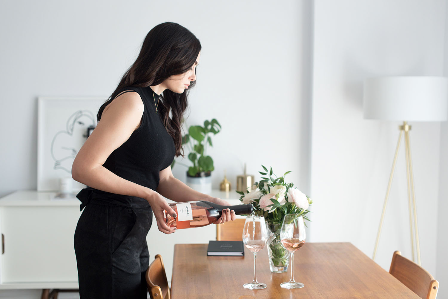 Top Winnipeg lifestyle blogger Cee Fardoe of Coco & Vera pours glasses of Adorada rose in her dining room