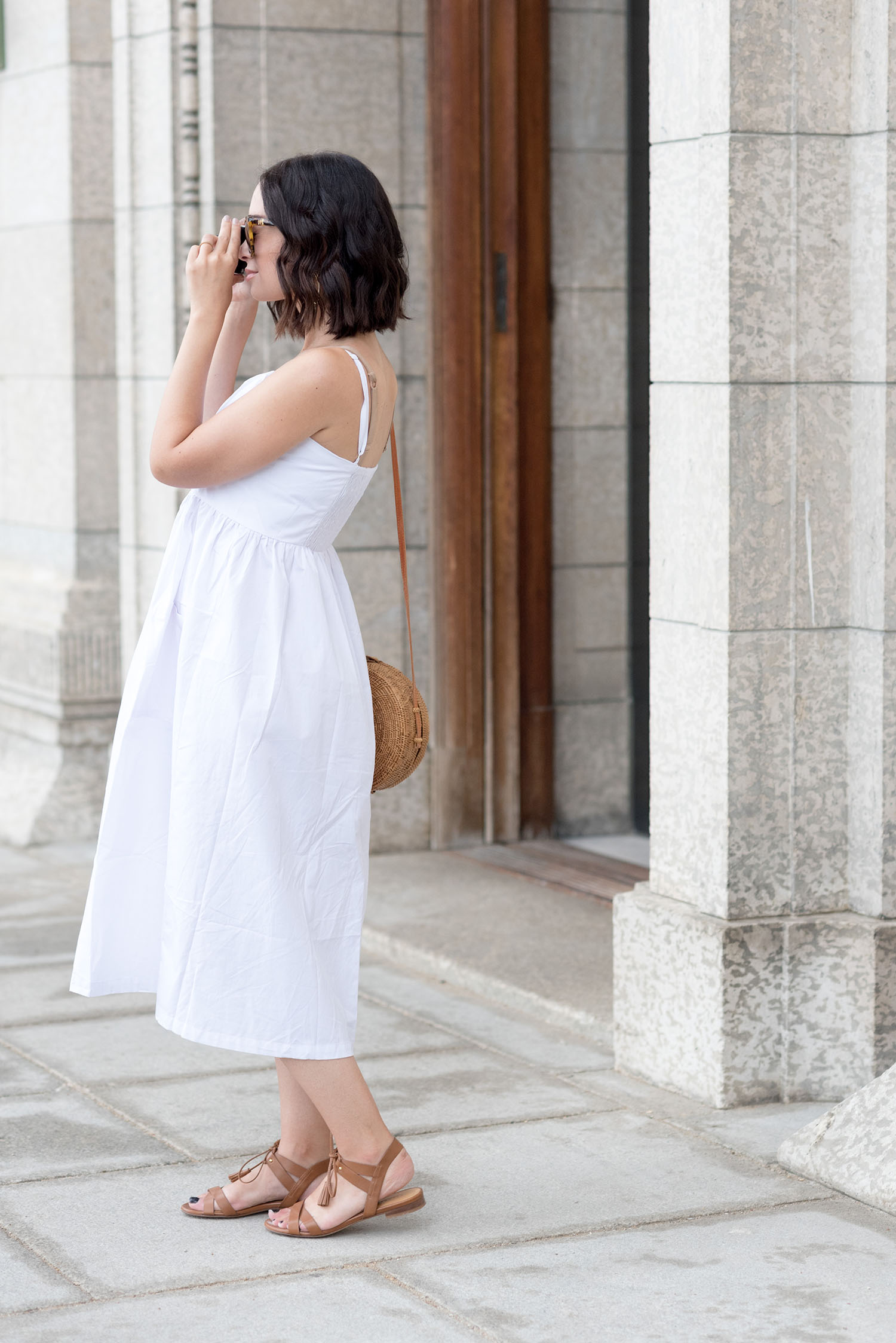 Top Canadian fashion blogger Cee Fardoe of Coco & Vera takes a photo while wearing a white Venidress midi dress