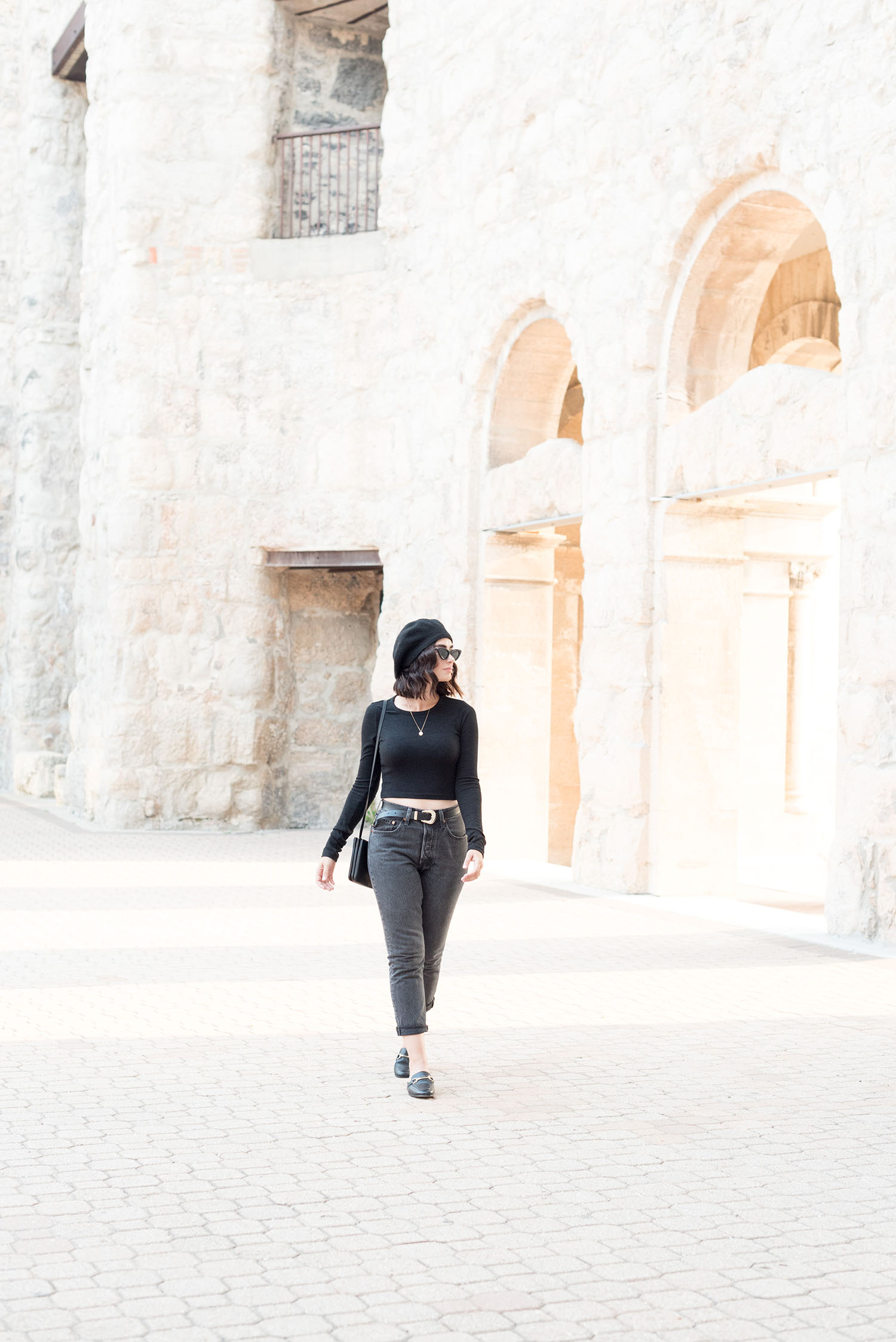 Top Paris fashion blogger Cee Fardoe of Coco & Vera walks through St. Boniface Cathedral in Winnipeg wearing Levi's 501 jeans and a cropped black sweater from Aritzia