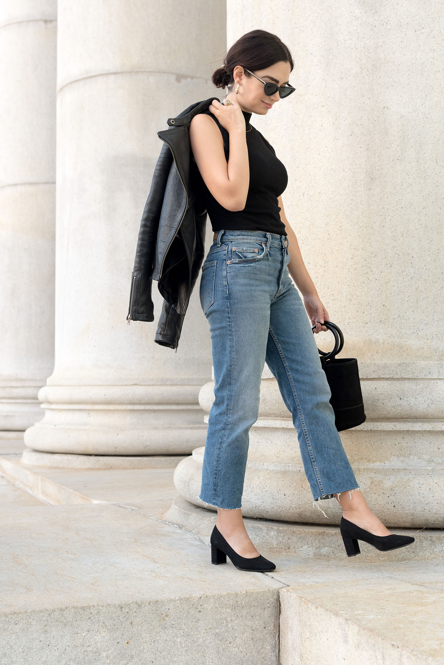Top Winnipeg fashion blogger Cee Fardoe of Coco & Vera walks outside the Bank of Montreal in Winnipeg wearing a Le Chateau top and Grlfrnd Helena jeans