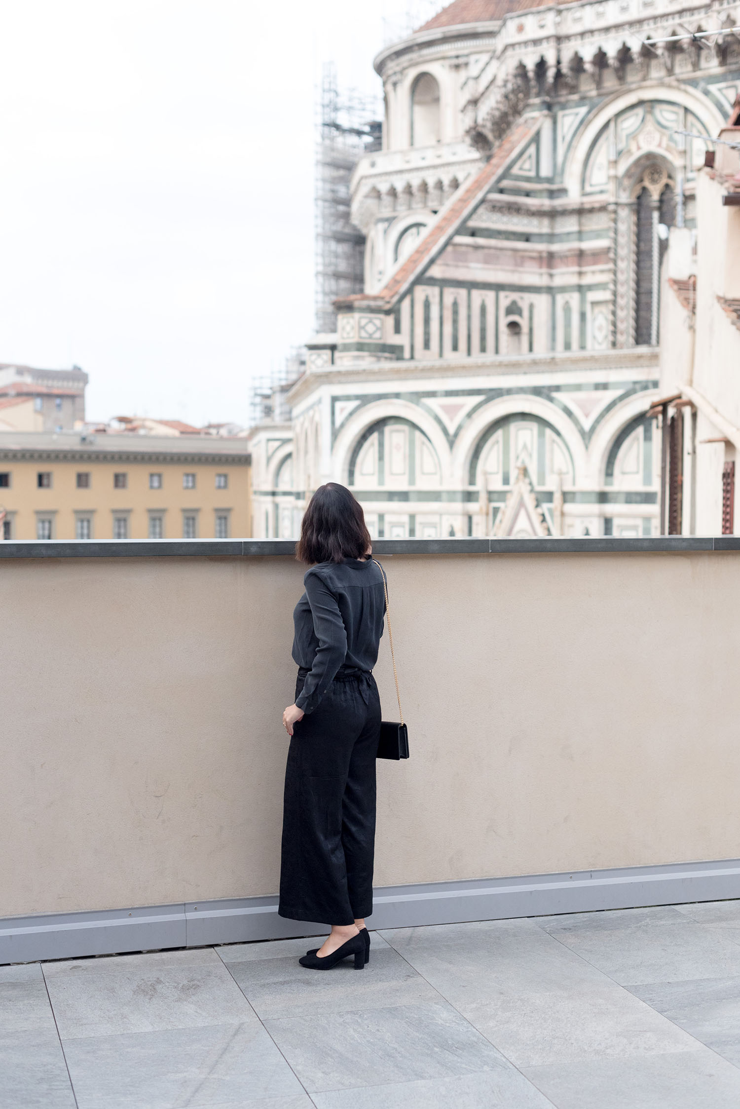Top Winnipeg fashion blogger Cee Fardoe of Coco & Vera stands on a terrace facing the Duomo in Florence, wearing Aritzia brocade culottes and carrying a Gucci Marmont handbag