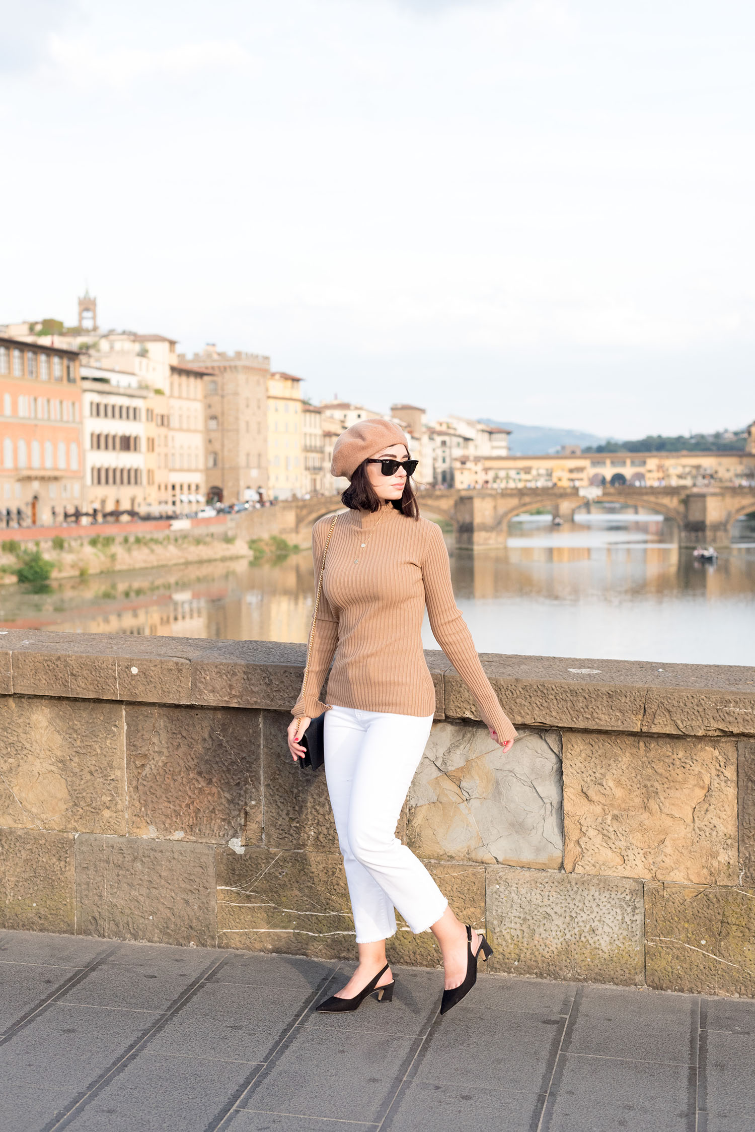 Top Winnipeg fashion blogger Cee Fardoe of Coco & Vera walks on Ponte Alla Carraia in Florence, wearing Mavi white jeans and Mango slingback heels