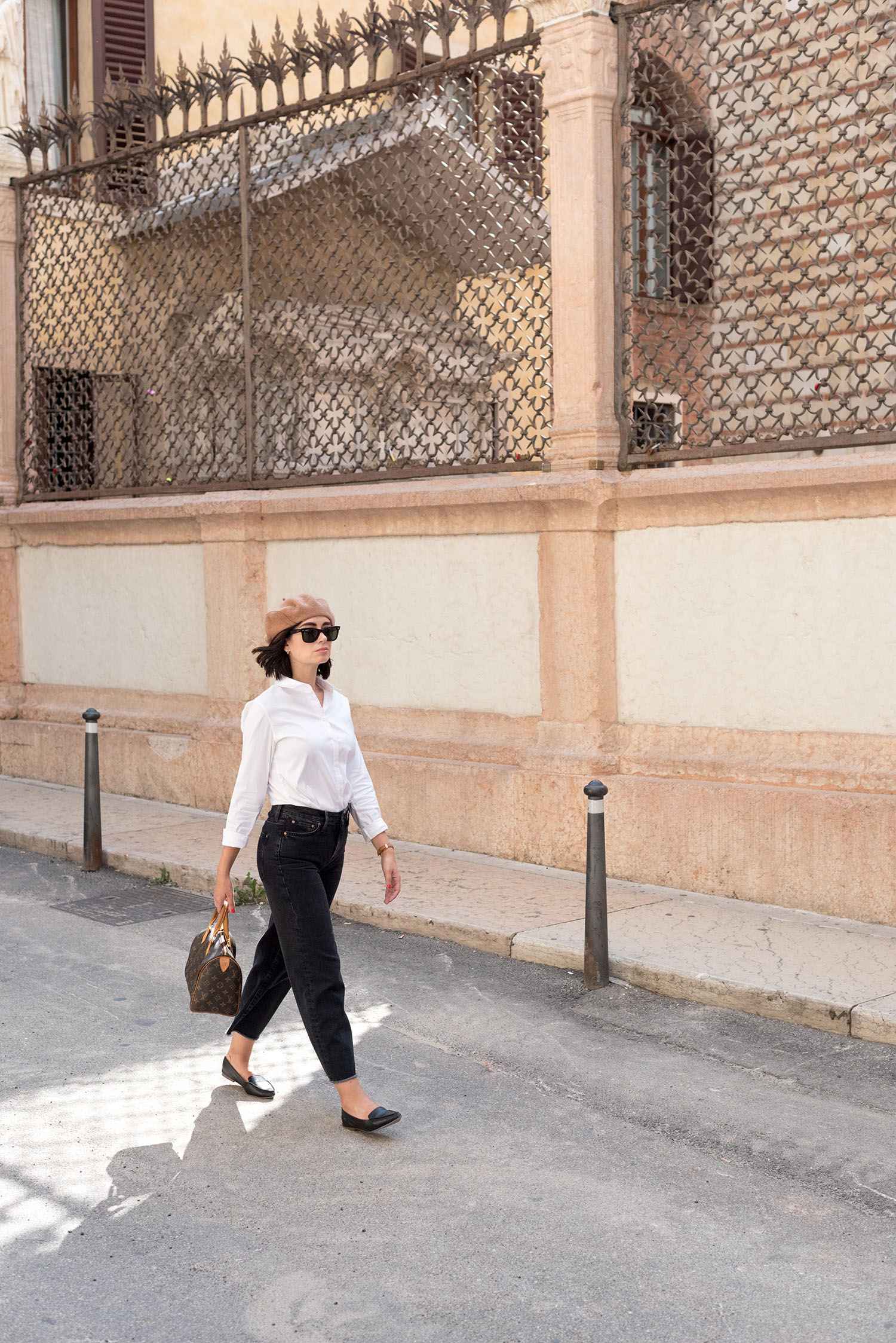 Top Canadian fashion blogger Cee Fardoe of Coco & Vera walks on the streets of Verona wearing Mavi wide leg jeans and J. Crew flats