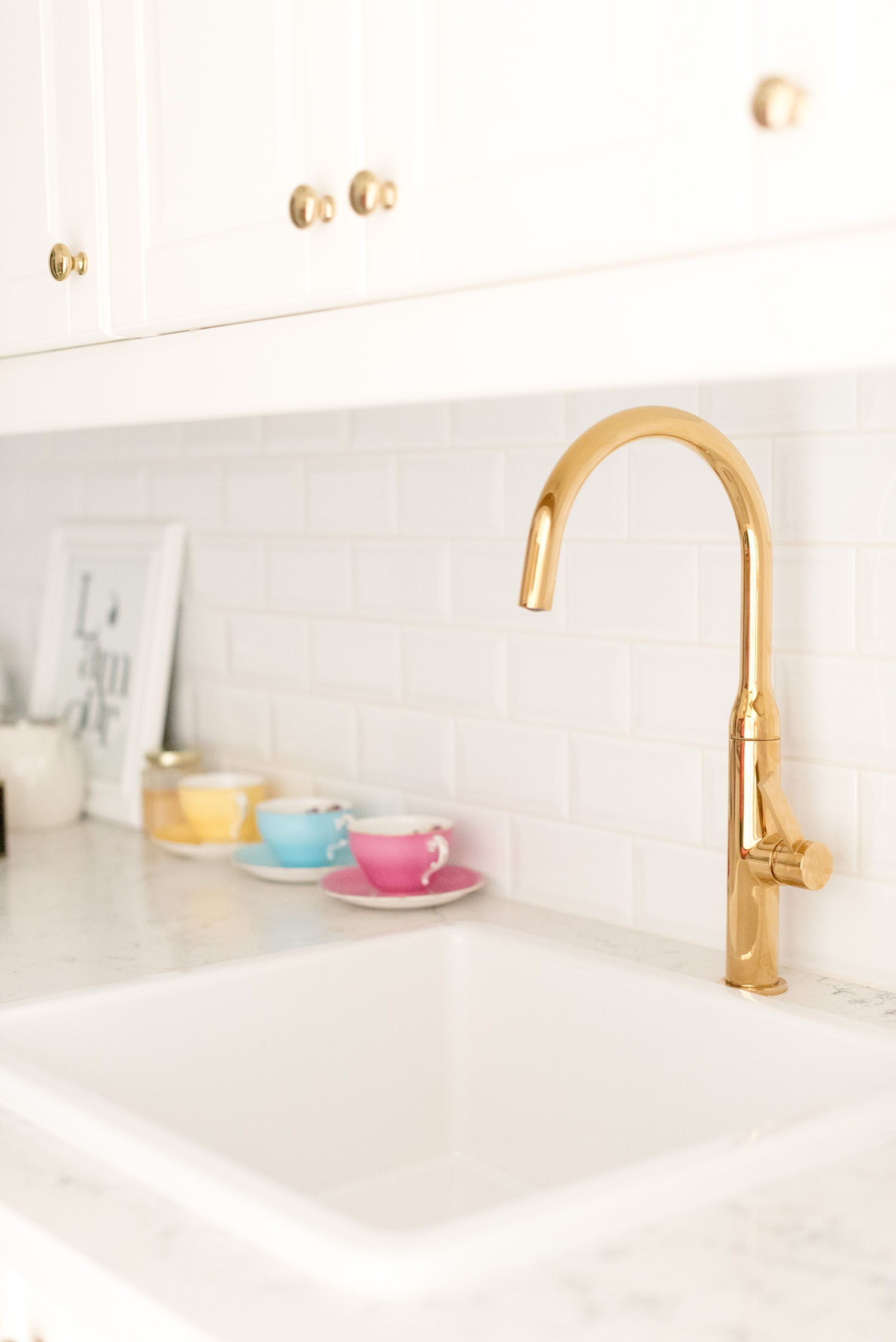 Details of the white skin and gold faucet in Cee Fardoe of Coco & Vera's Winnipeg kitchen