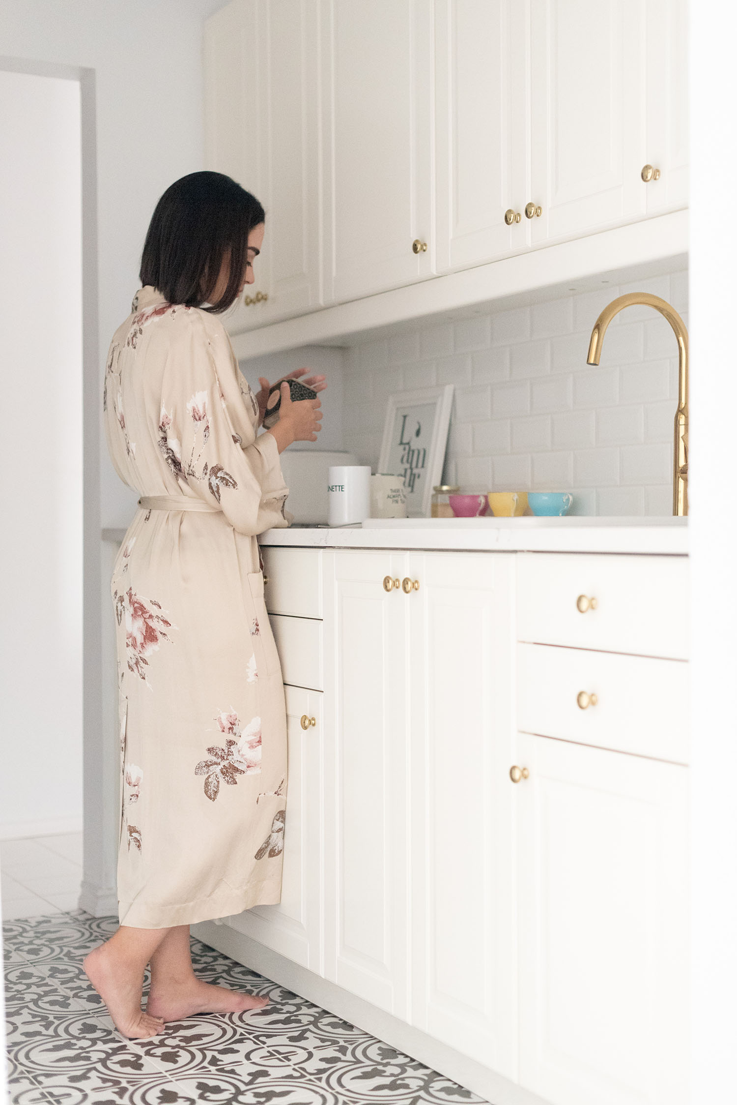 Top Winnipeg lifestyle blogger Cee Fardoe of Coco & Vera stands in her condo kitchen wearing an Aritzia kimono and pouring Sloane tea