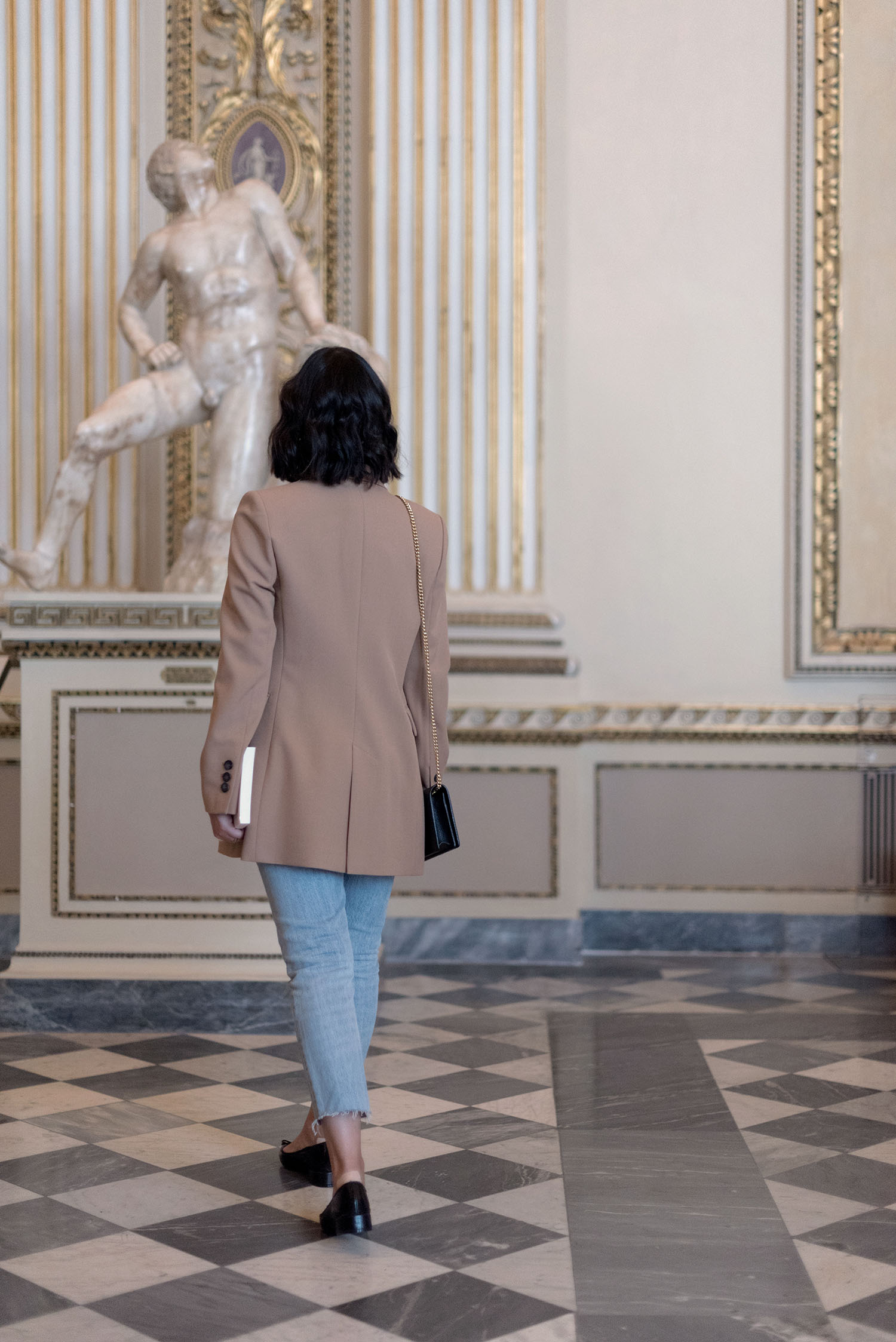 Top Winnipeg travel blogger Cee Fardoe of Coco & Vera walks in the Uffizi Gallery in Florence, Italy, wearing Levi's jeans and a Zara camel blazer