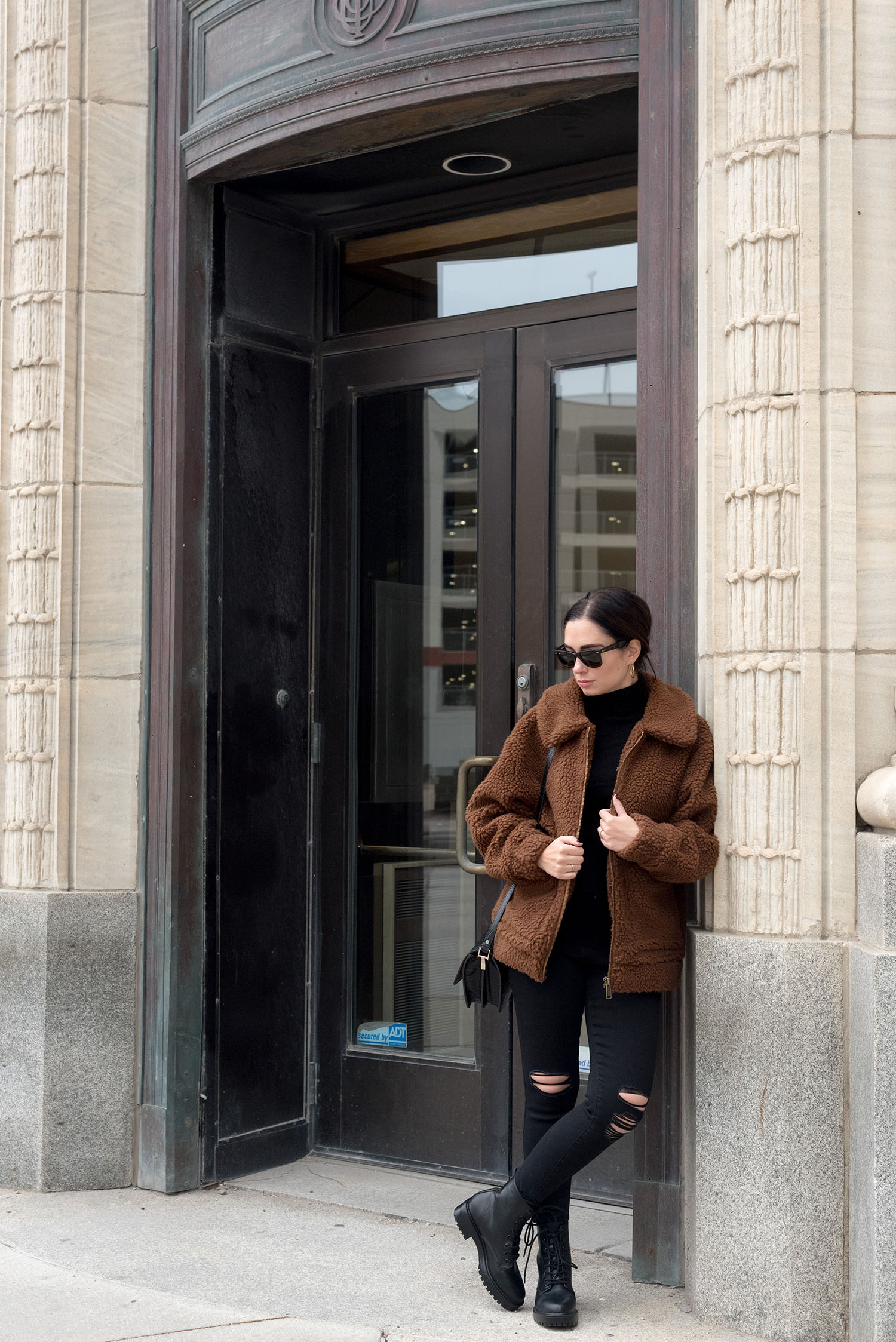 Top Winnipeg fashion blogger Cee Fardoe of Coco & Vera stands outside Birks Jewelers wearing a Garage Clothing teddy coat and Forever 21 combat boots