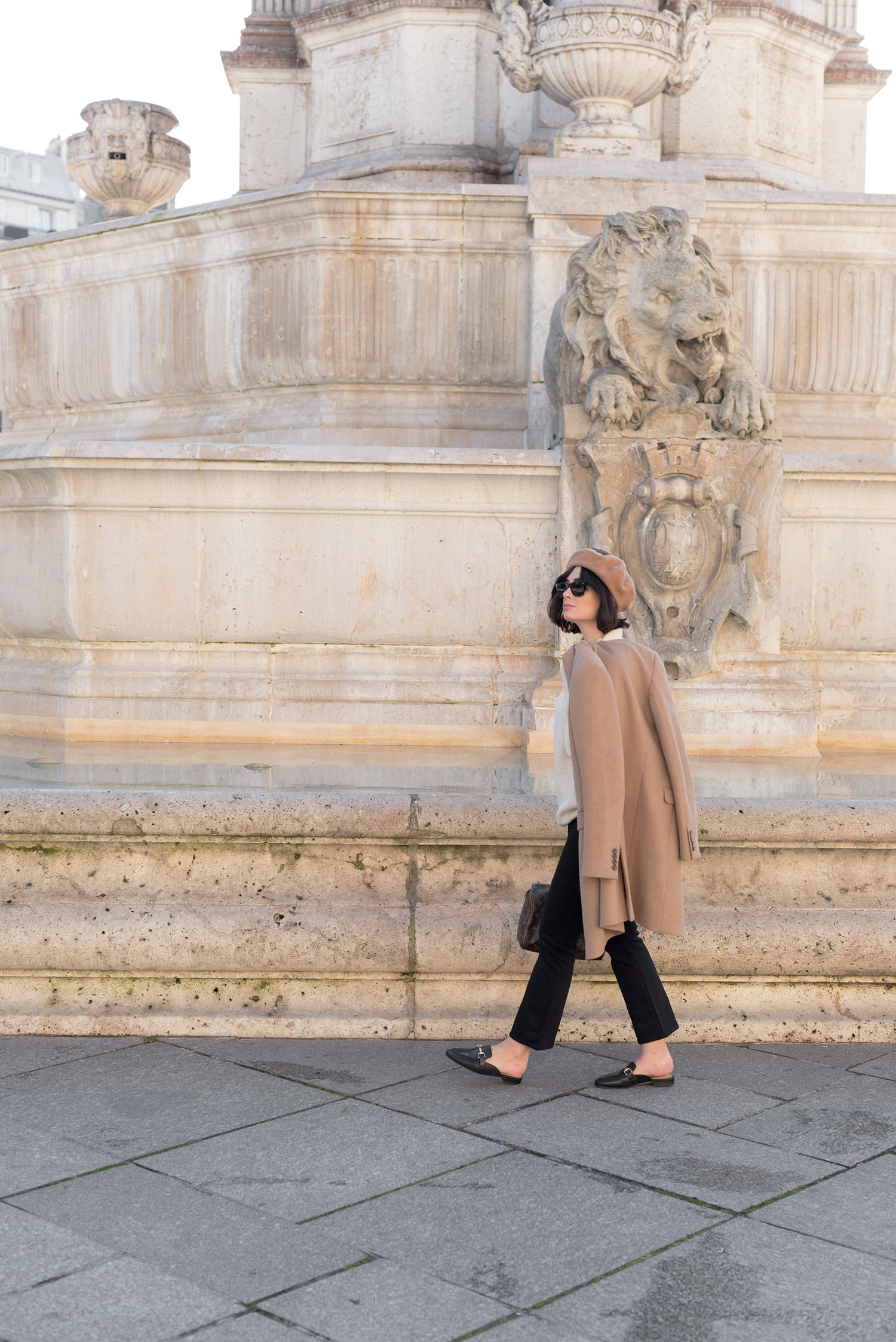 Top Canadian fashion blogger Cee Fardoe of Coco & Vera walks past the Saint-Sulpice fountain in Paris, wearing Mavi cropped jeans and Jonak mules