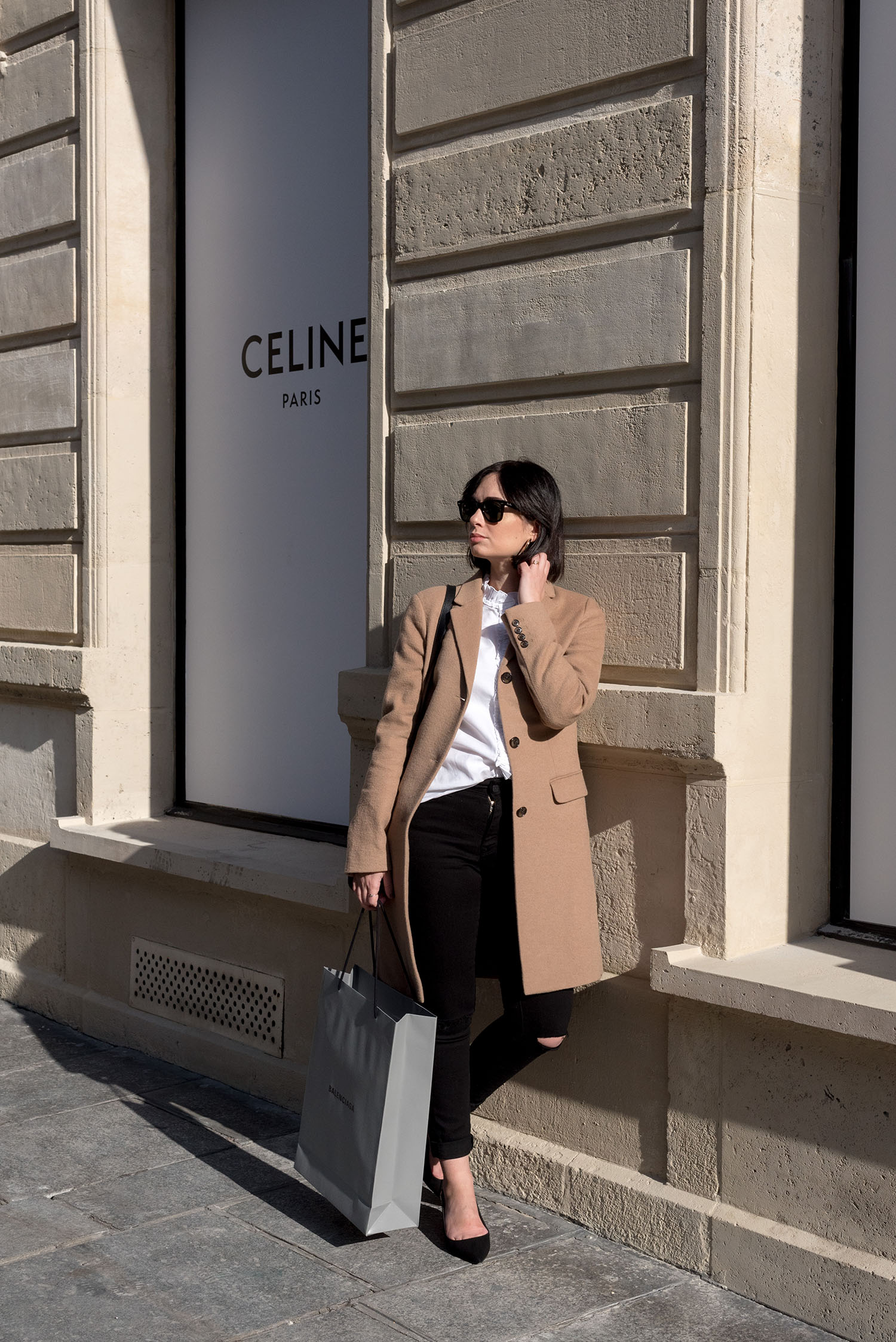 Top Winnipeg fashion blogger Cee Fardoe of Coco & Vera outside Celine on Avenue Montaigne in Paris, wearing a Uniqlo camel coat and Mavi skinny jeans