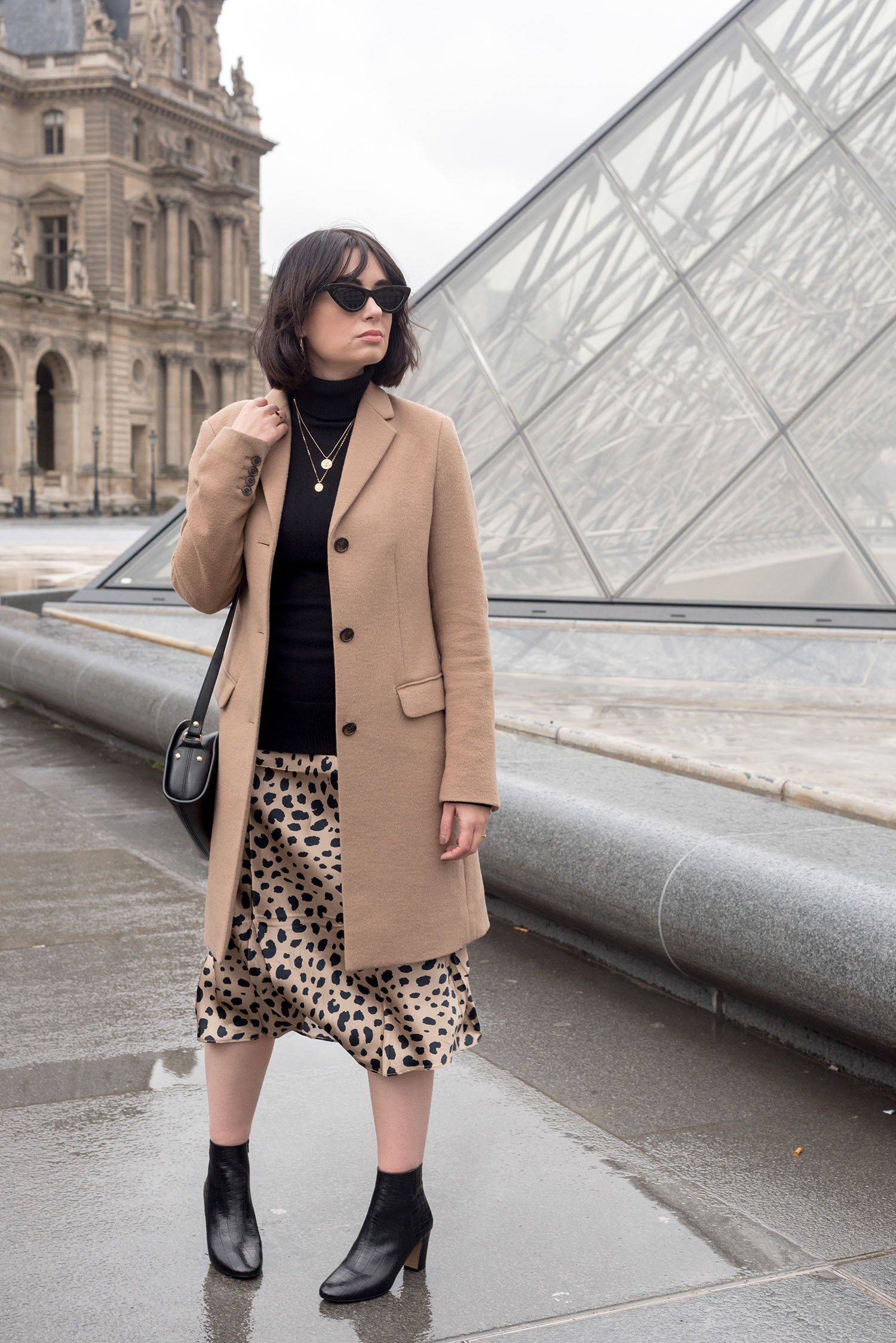 Top Canadian fashion blogger Cee Fardoe of Coco & Vera stands outside the Louvre museum in Paris, wearing a Realisation Par... leopard skirt and Minelli ankle boots