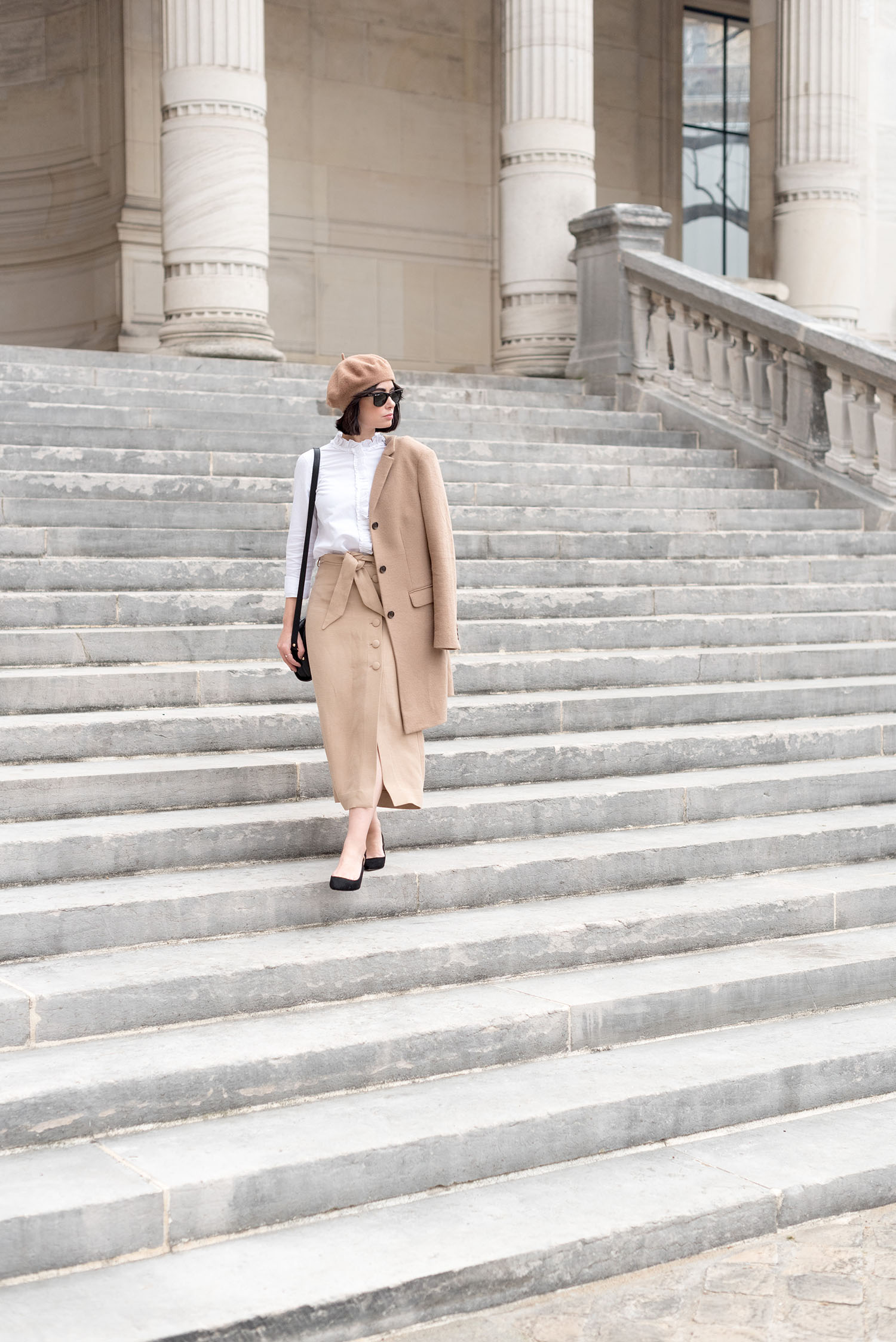 Top Canadian fashion blogger Cee Fardoe of Coco & Vera walks down the stairs at Palais Galliera in Paris wearing an & Other Stories skirt and Mango block heels