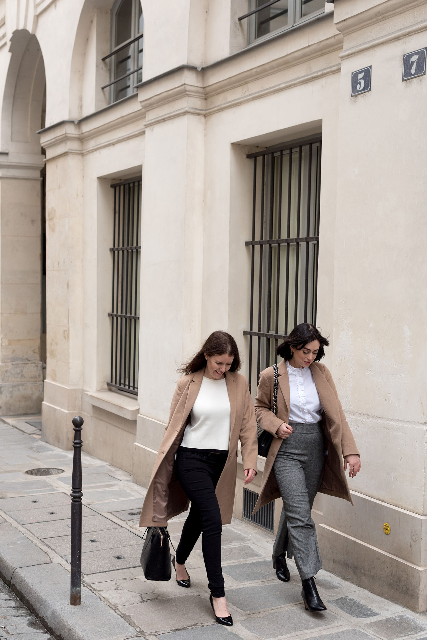 Top Canadian fashion bloggers Cee Fardoe of Coco & Vera and Lyndi Barrett of Style Calling walk at the Palais-Royal in Paris, wearing Uniqlo camel coats