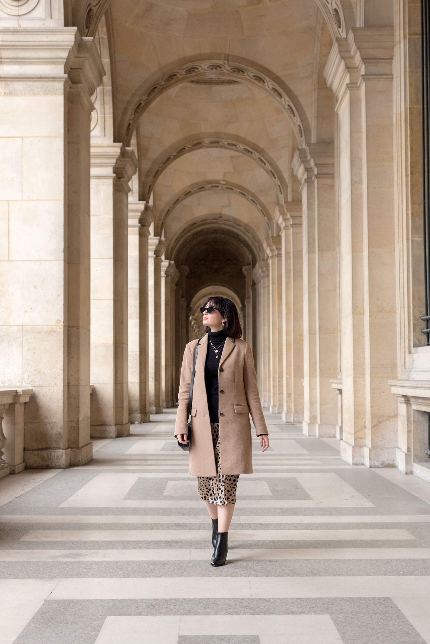 Top Winnipeg fashion blogger Cee Fardoe of Coco & Vera walks at the Louvre in Paris, wearing a Realisation Par... Naomi skirt and Uniqlo camel coat