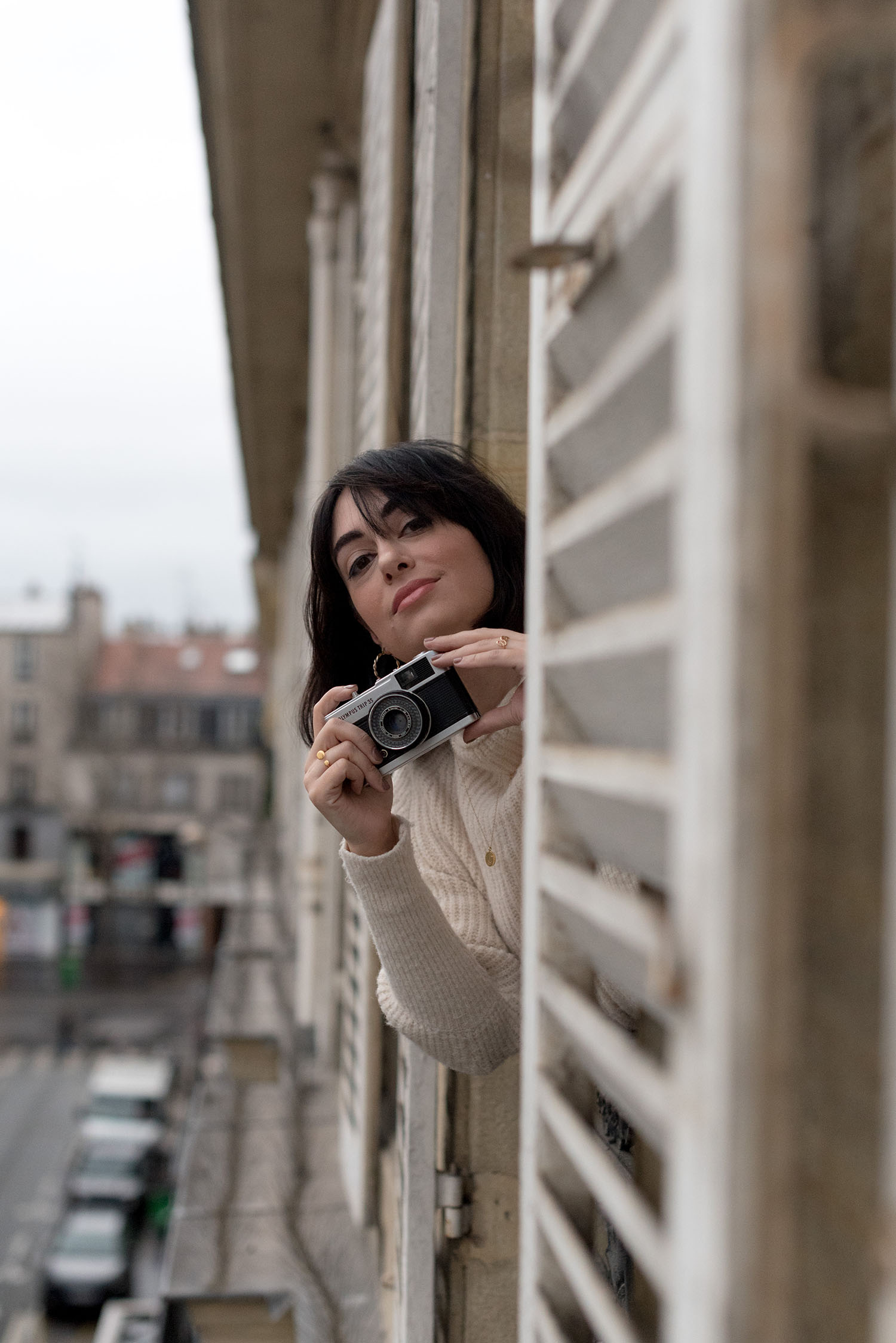 Top Winnipeg fashion blogger Cee Fardoe of Coco & Vera takes a photo out the window of a 14th arrondissement apartment in Paris, using an Olympus Trip camera