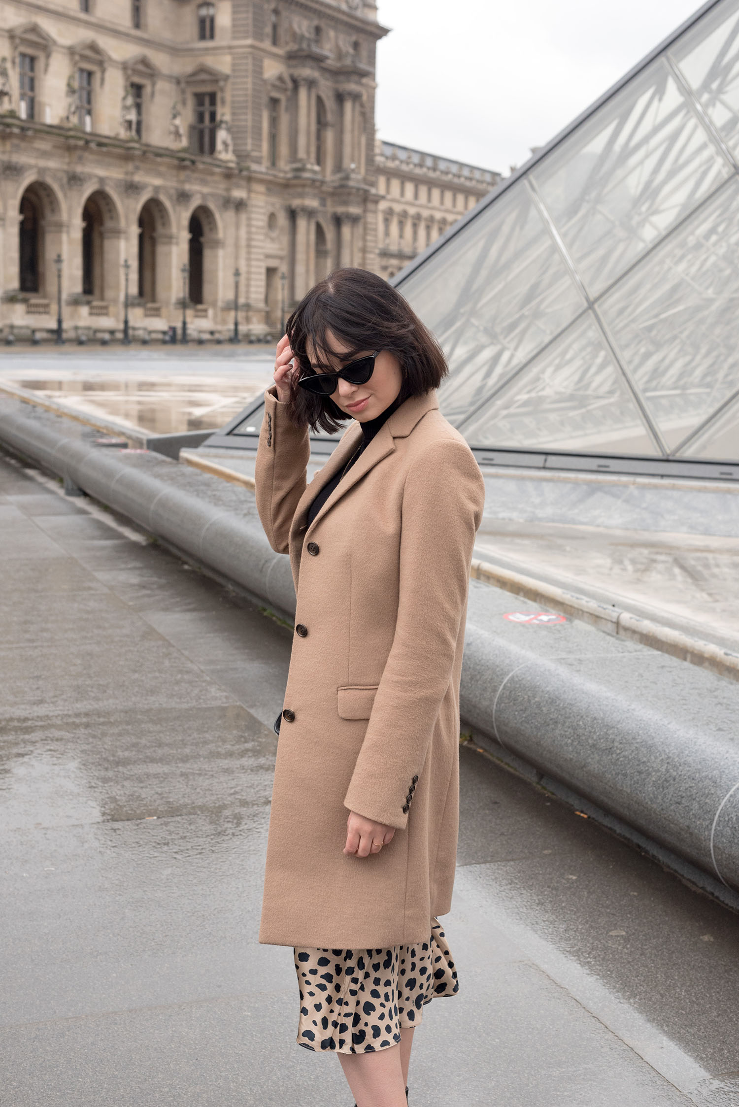 Portrait of top Canadian fashion blogger Cee Fardoe of Coco & Vera at the Louvre in Paris, wearing Zara cat eye sunglasses and a Uniqlo camel coat