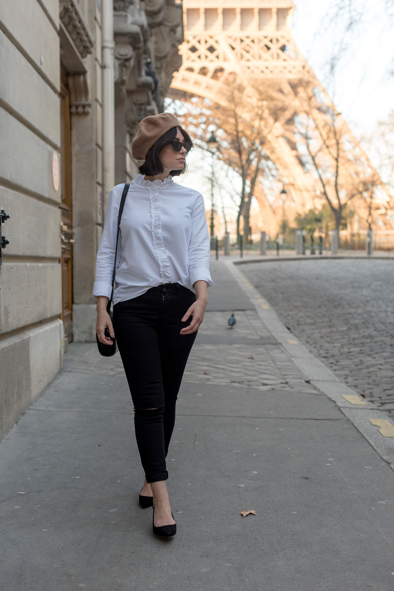 Top Winnipeg fashion blogger Cee Fardoe of Coco & Vera walks near the Eiffel Tower wearing Mavi jeans and a Sezane blouse