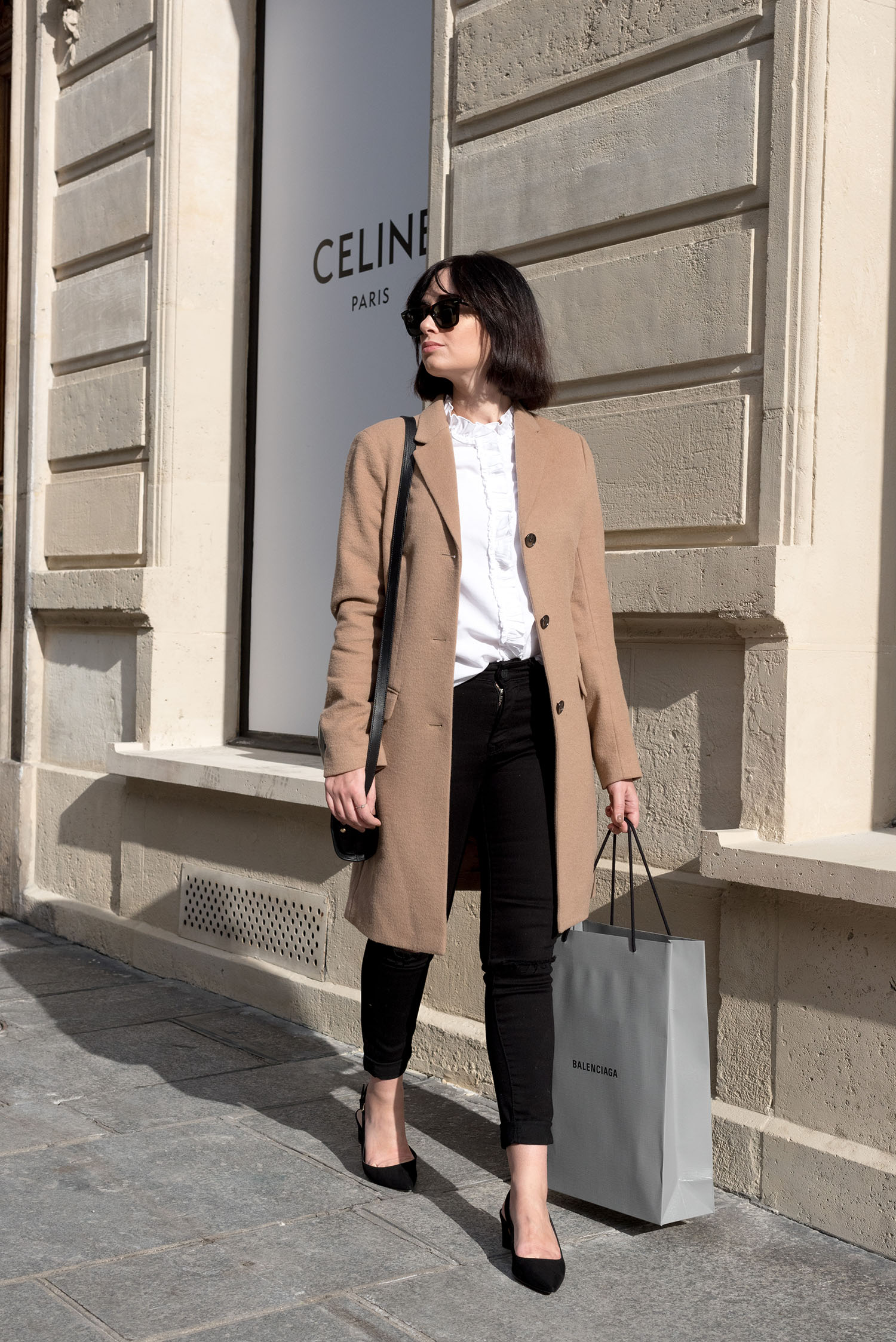 Top Canadian fashion blogger Cee Fardoe of Coco & Vera on Avenue Montaigne in Paris, wearing a Uniqlo camel coat and Mavi skinny jeans