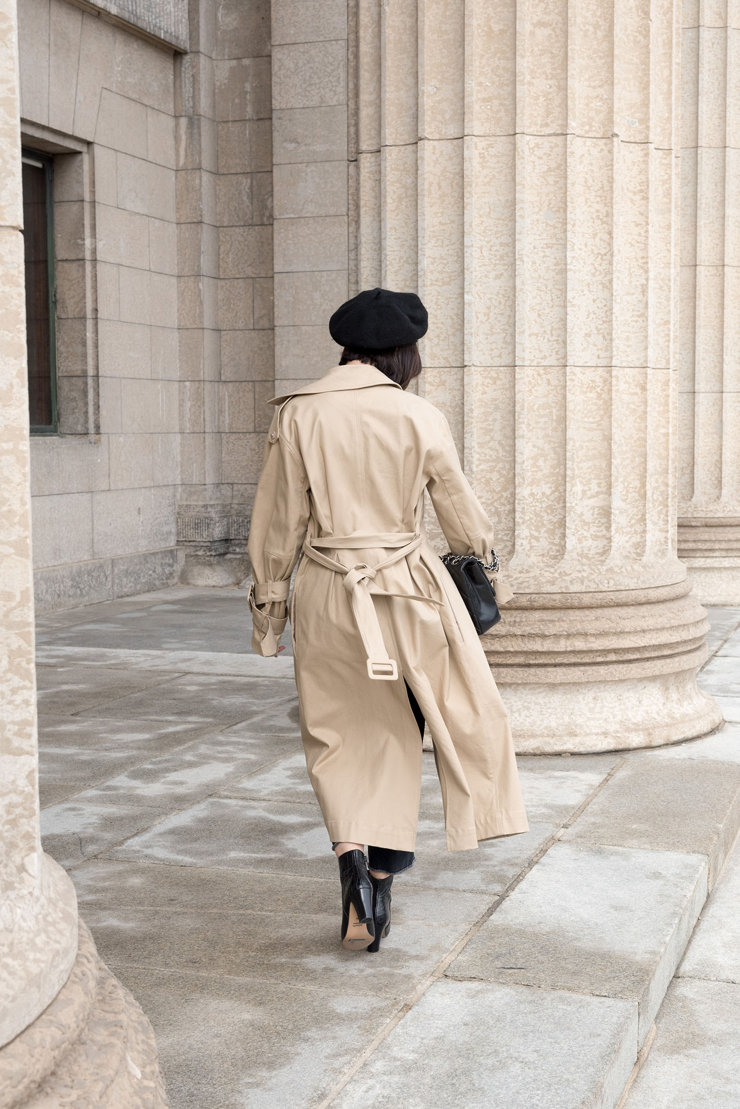 Top Canadian fashion blogger Cee Fardoe of Coco & Vera walks outside the Manitoba Legislature wearing an H&M trench coat and carrying a Chanel handbag