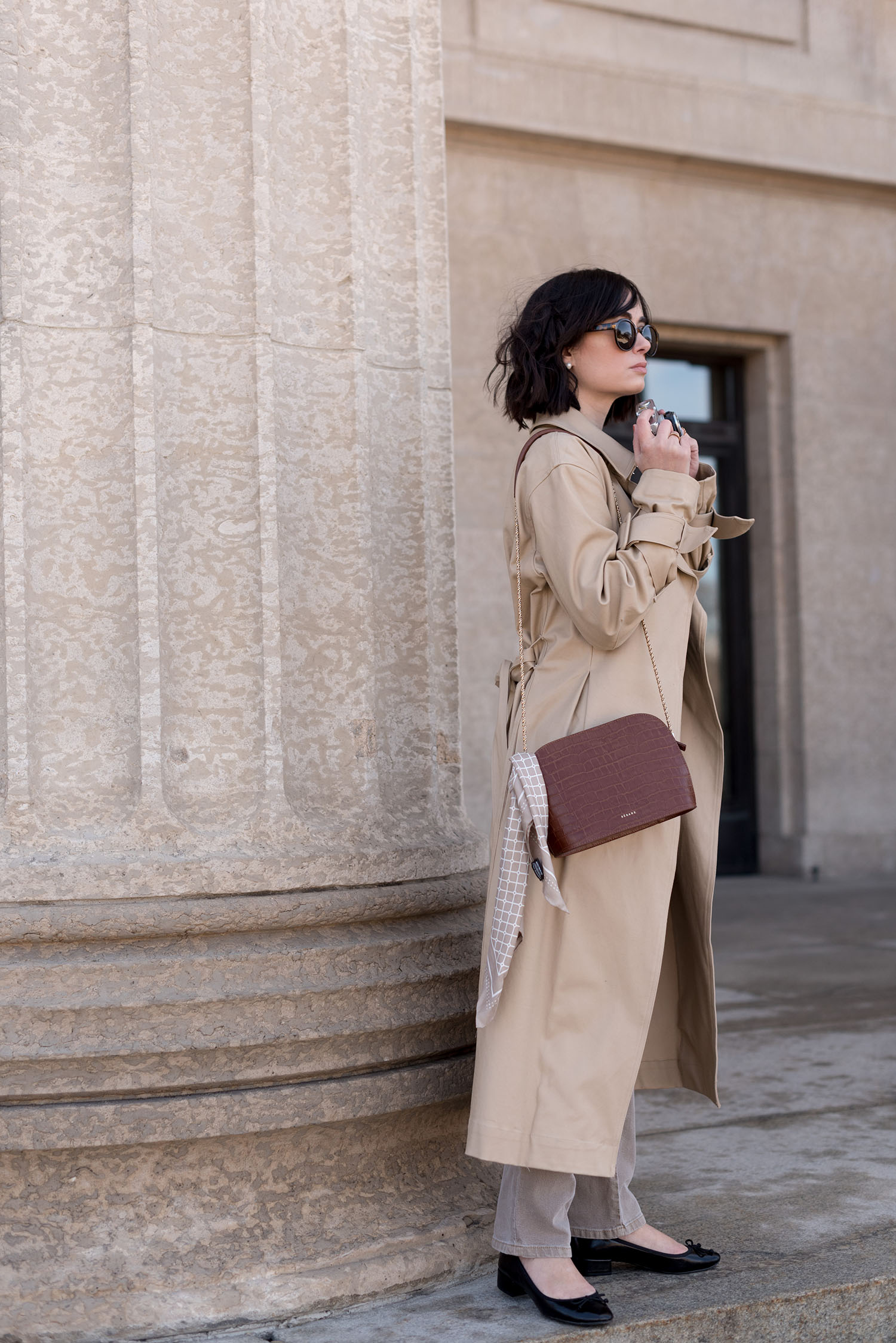 Top Winnipeg fashion blogger Cee Fardoe of Coco & Vera wears an H&M trench and carries a Sezane handbag at the Manitoba Legislature