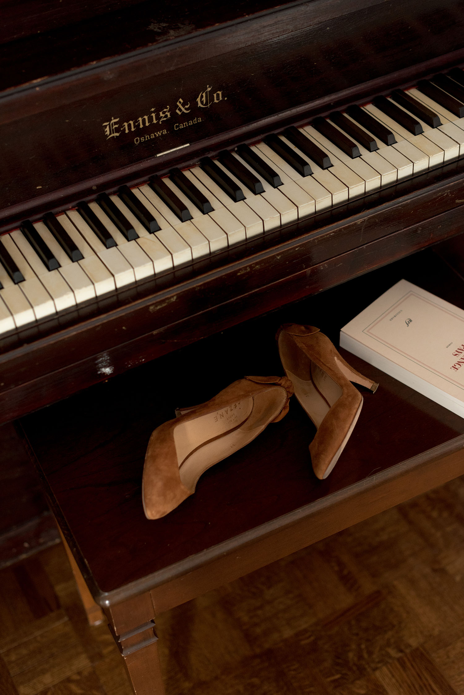 A pair of Sezane pumps and an Editions Gallimard novel on a piano bench, as captured by top Canadian fashion blogger Cee Fardoe of Coco & Vera