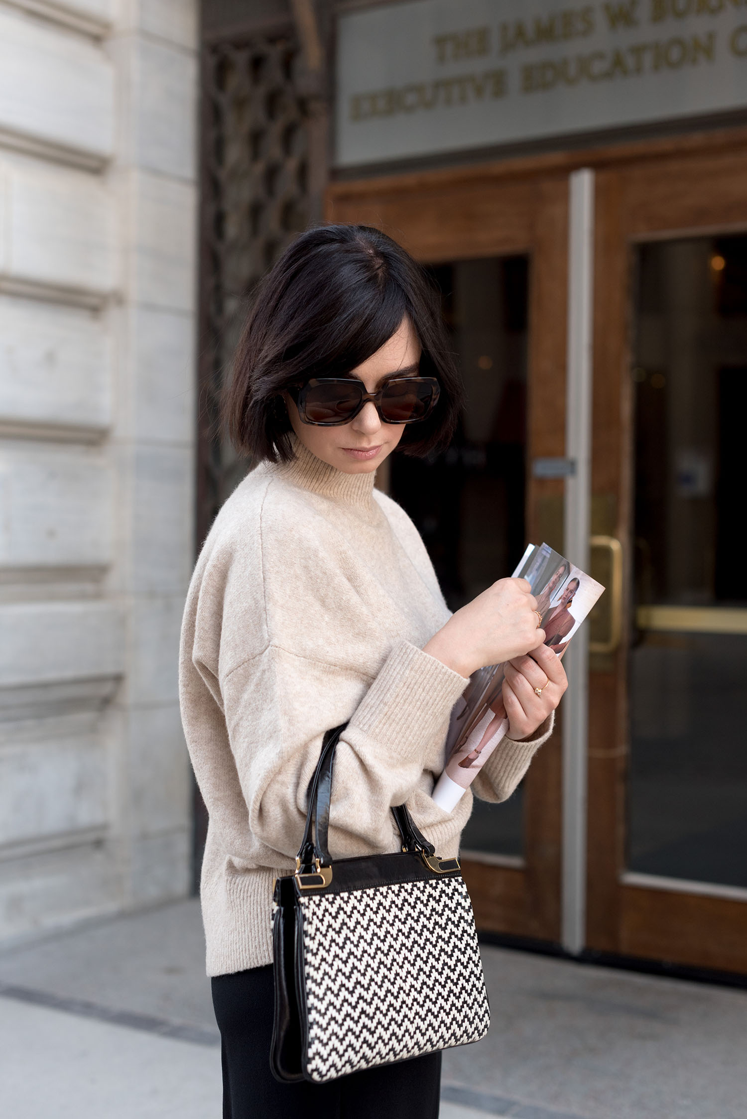 Portrait of top Canadian fashion blogger Cee Fardoe of Coco & Vera, holding a copy of Vogue magazine, wearing Mango sunglasses and carrying a vintage handbag