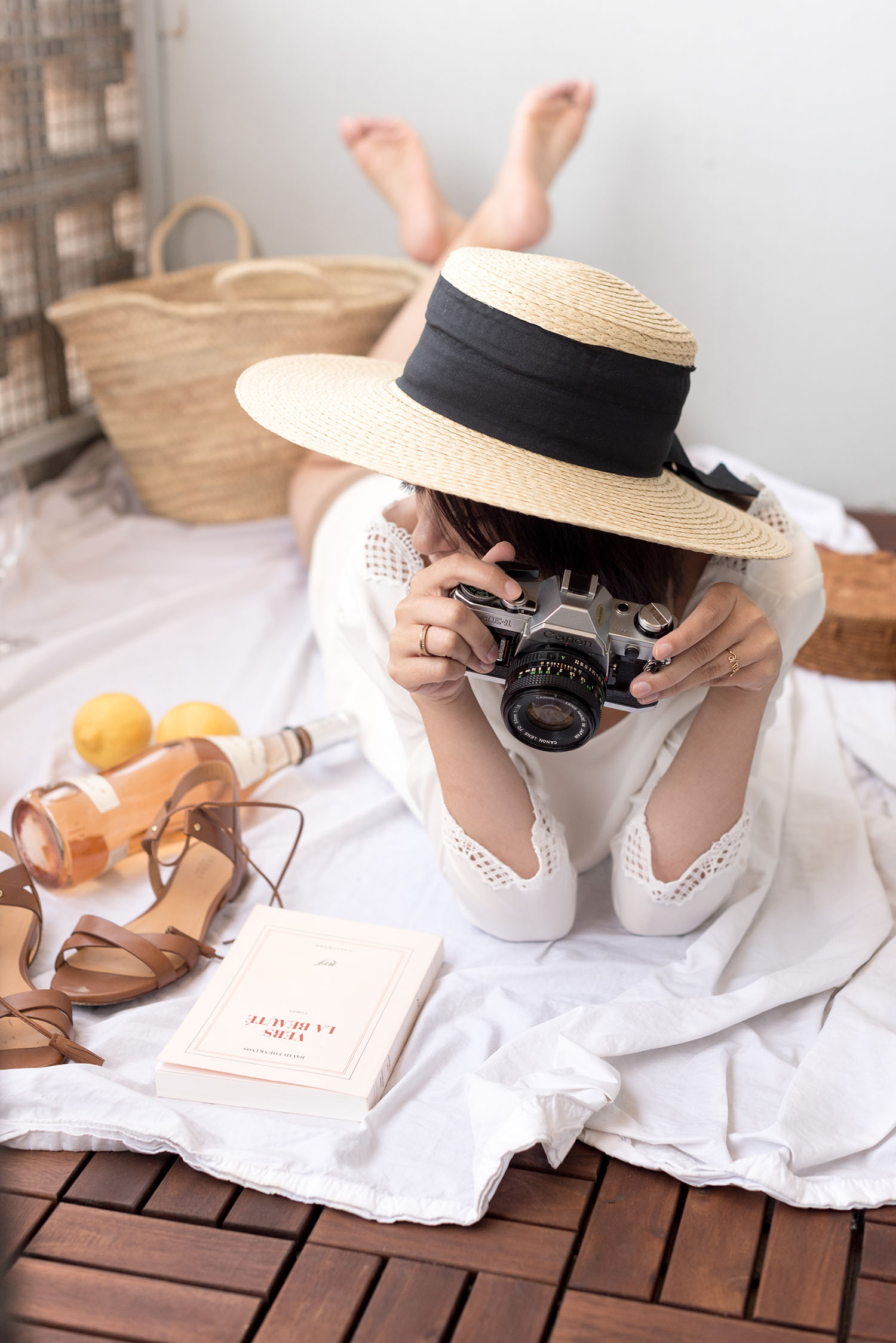 Top Canadian fashion blogger Cee Fardoe of Coco & Vera holds a Canon AE-1 camera while wearing a Mango straw hat