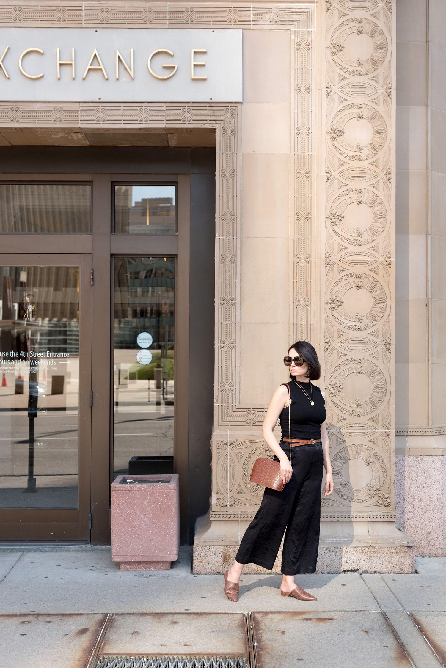 Top Canadian fashion blogger Cee Fardoe of Coco & Vera walks in Minneapolis, Minnesota, wearing Aritzia satin culottes and carrying a Sezane Victor handbag