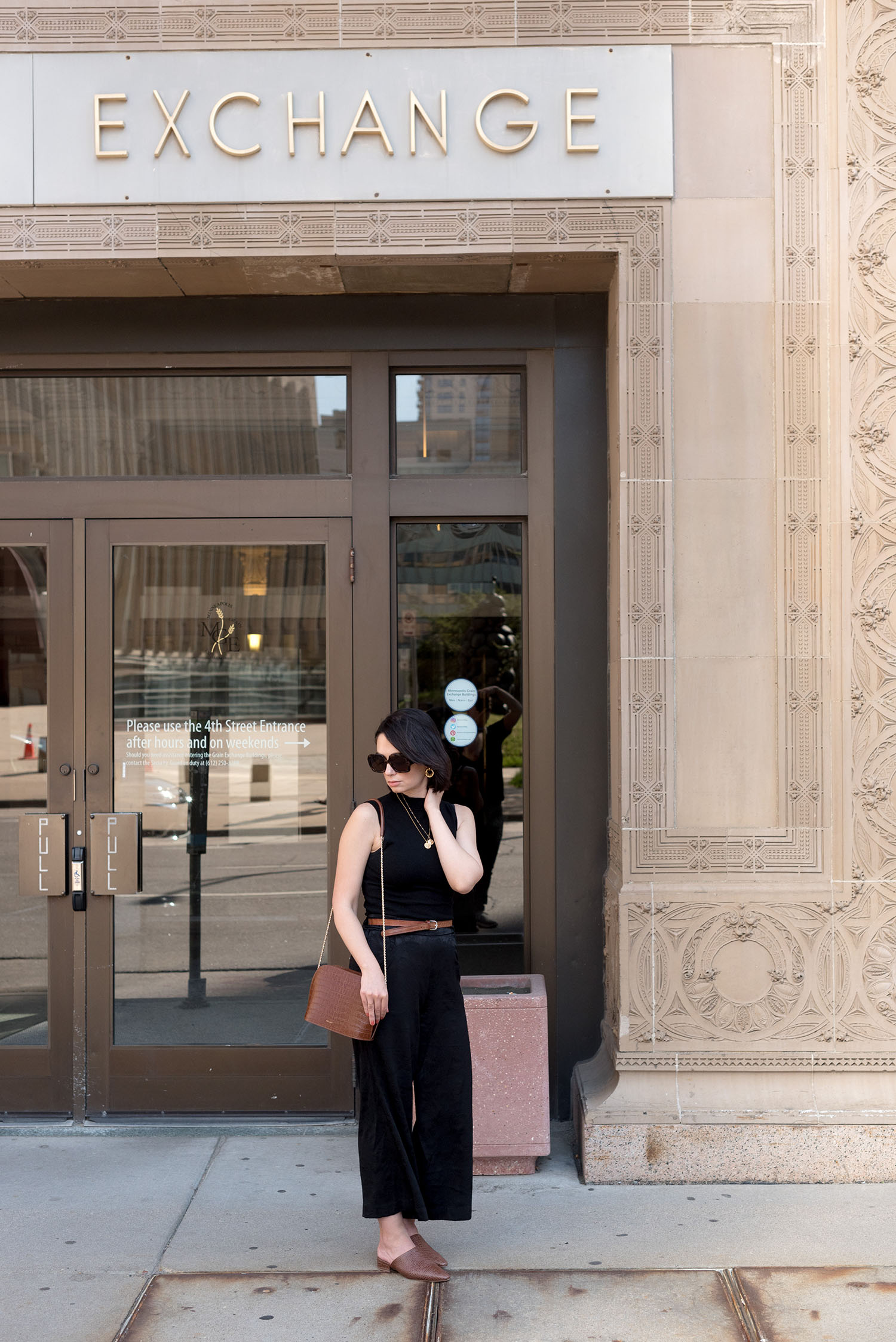 Top Winnipeg fashion blogger Cee Fardoe of Coco & Vera stands outside the Grain Exchange building in Minneapolis, wearing a vintage belt and Aritzia brocade culottes while contemplating community