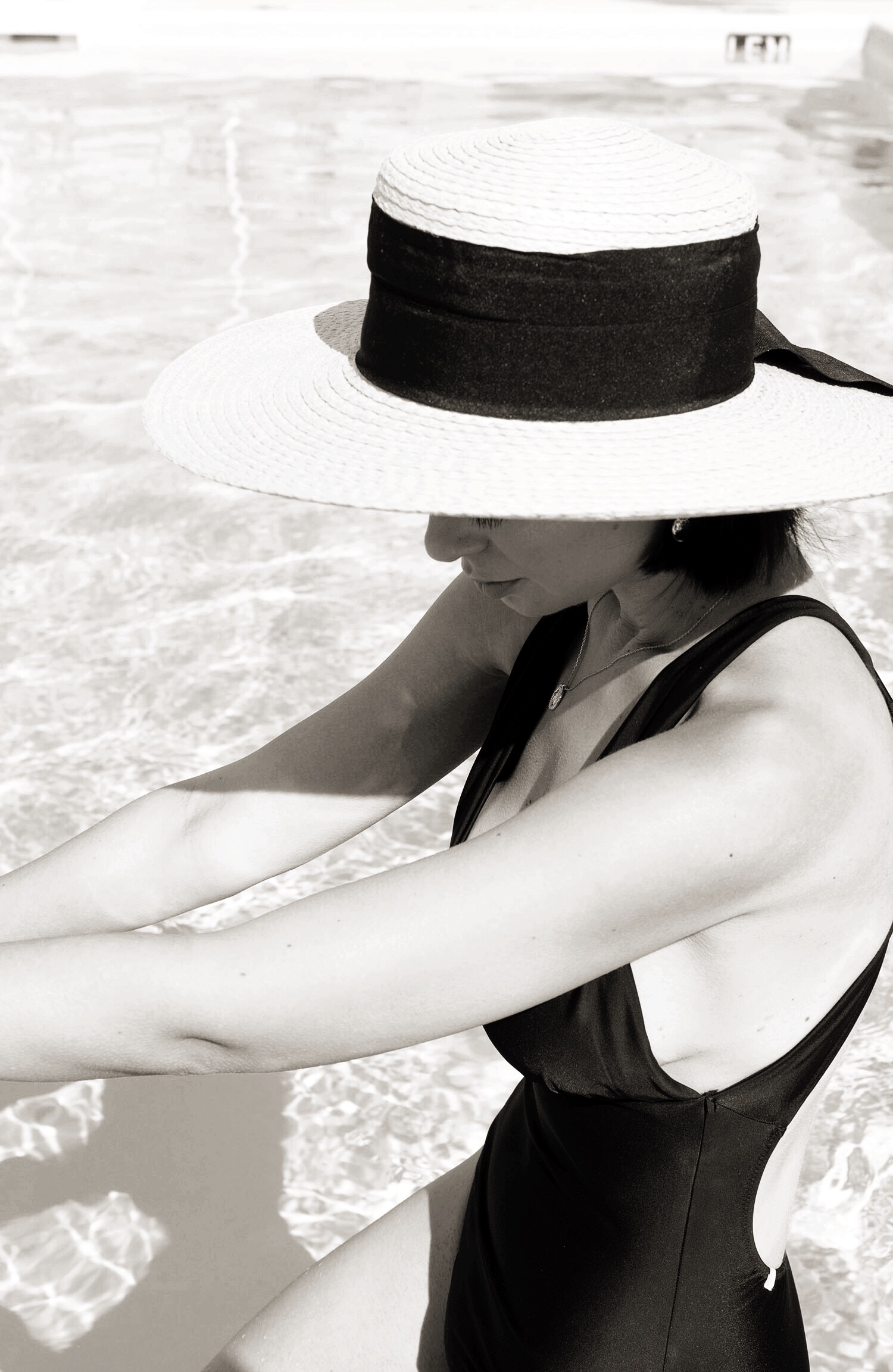 Portrait of top Winnipeg fashion blogger Cee Fardoe of Coco & Vera wearing a Mango straw hat and Summersalt The Plunge swimsuit