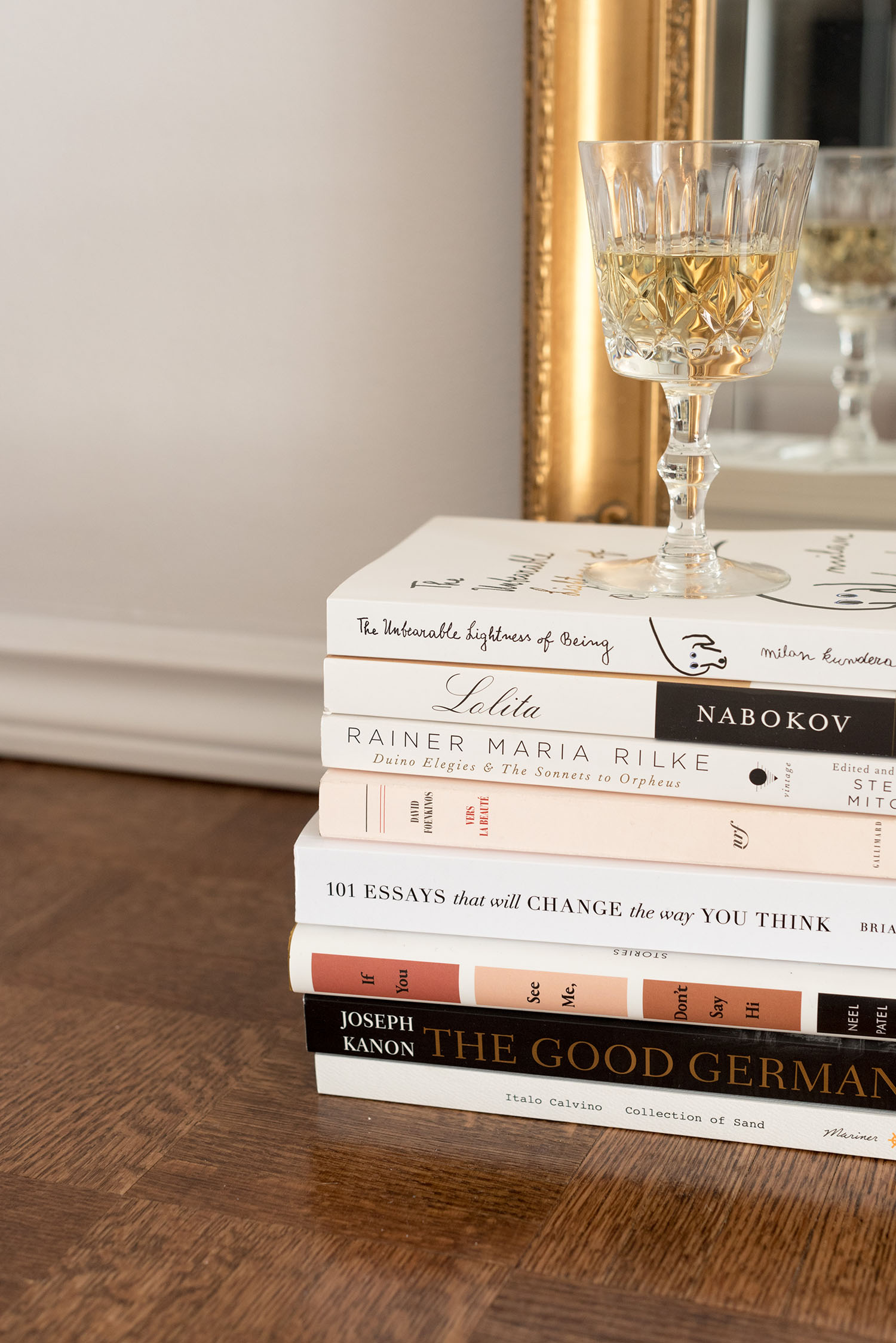 Coco & Vera - A book stack and a glass of white wine