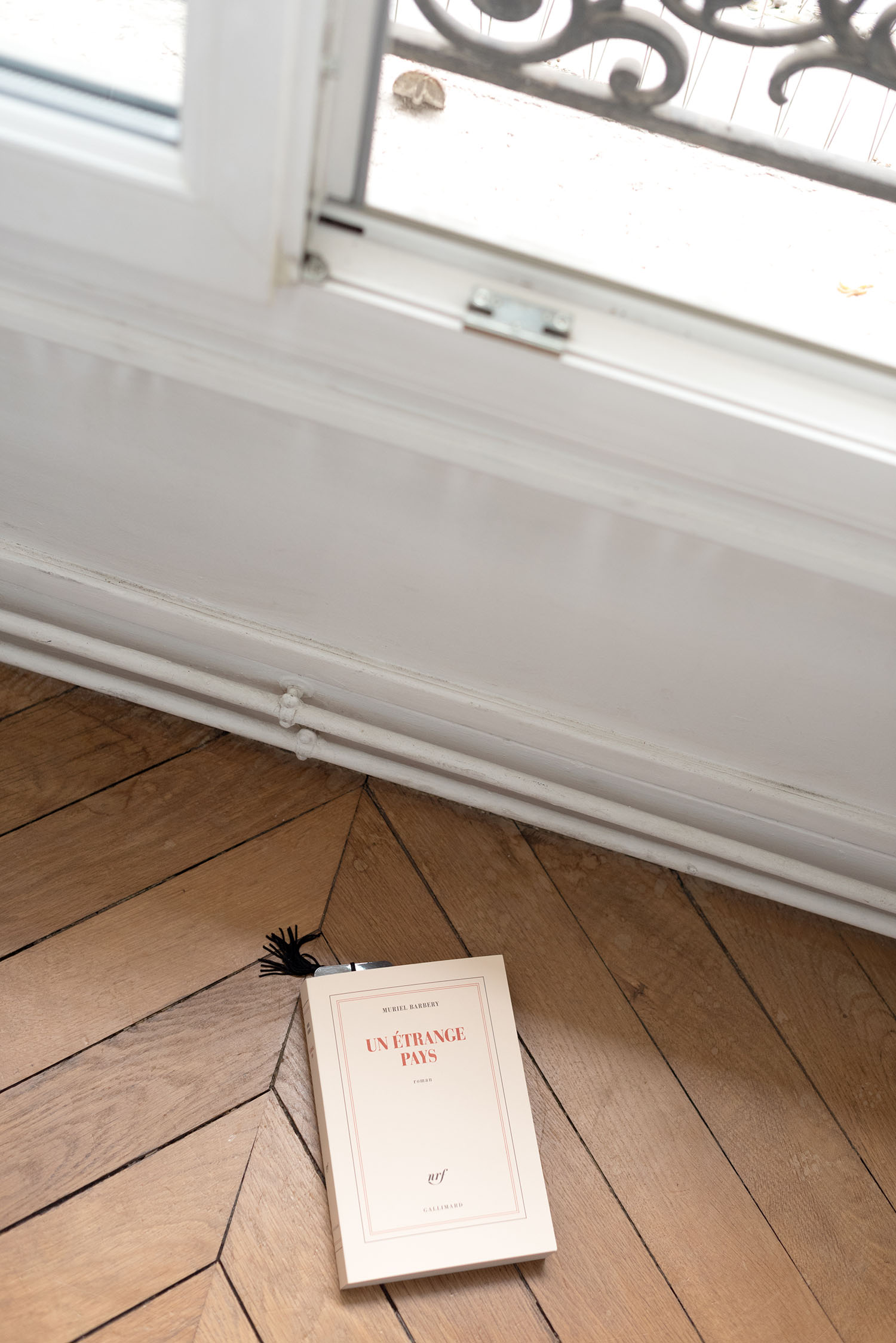 Coco & Vera - Un Etrange Pays, novel by Muriel Barbery, on a parquet floor in a Paris apartment