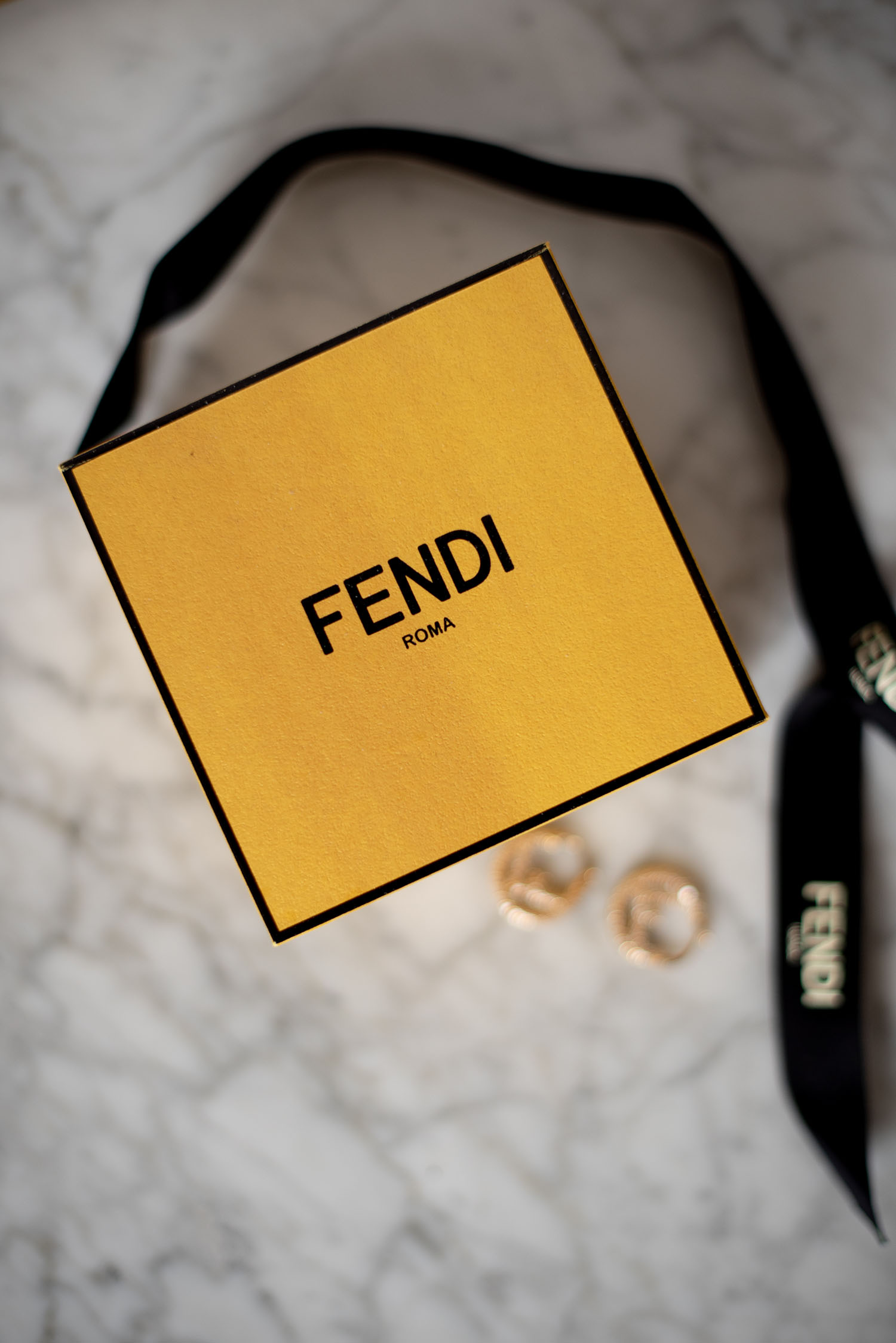 Coco & Vera - Fendi Roma earring box with Fendi ribbon and earrings on marble background