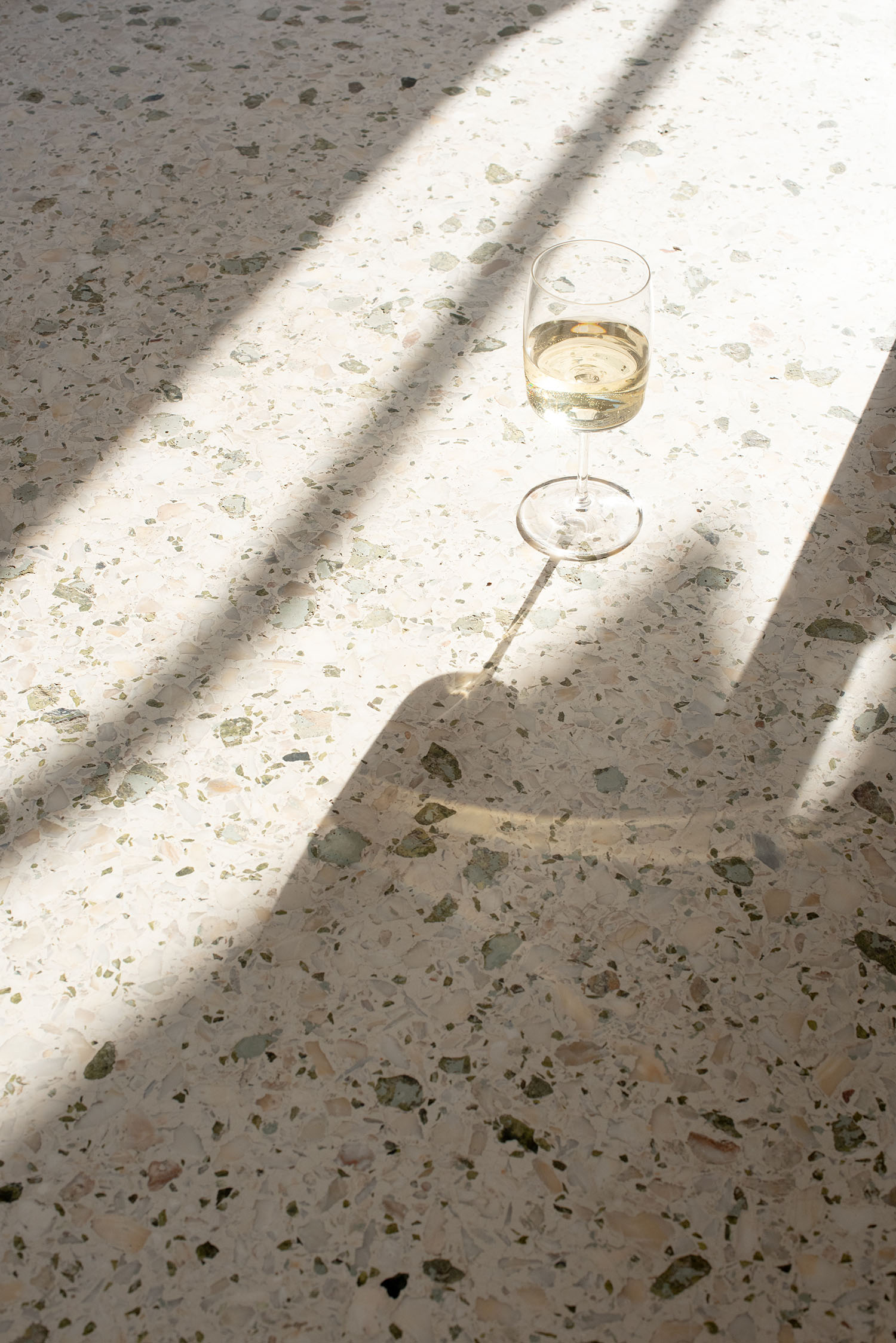 Coco & Vera - Glass of white wine on a terrazzo marble balcony in Athens