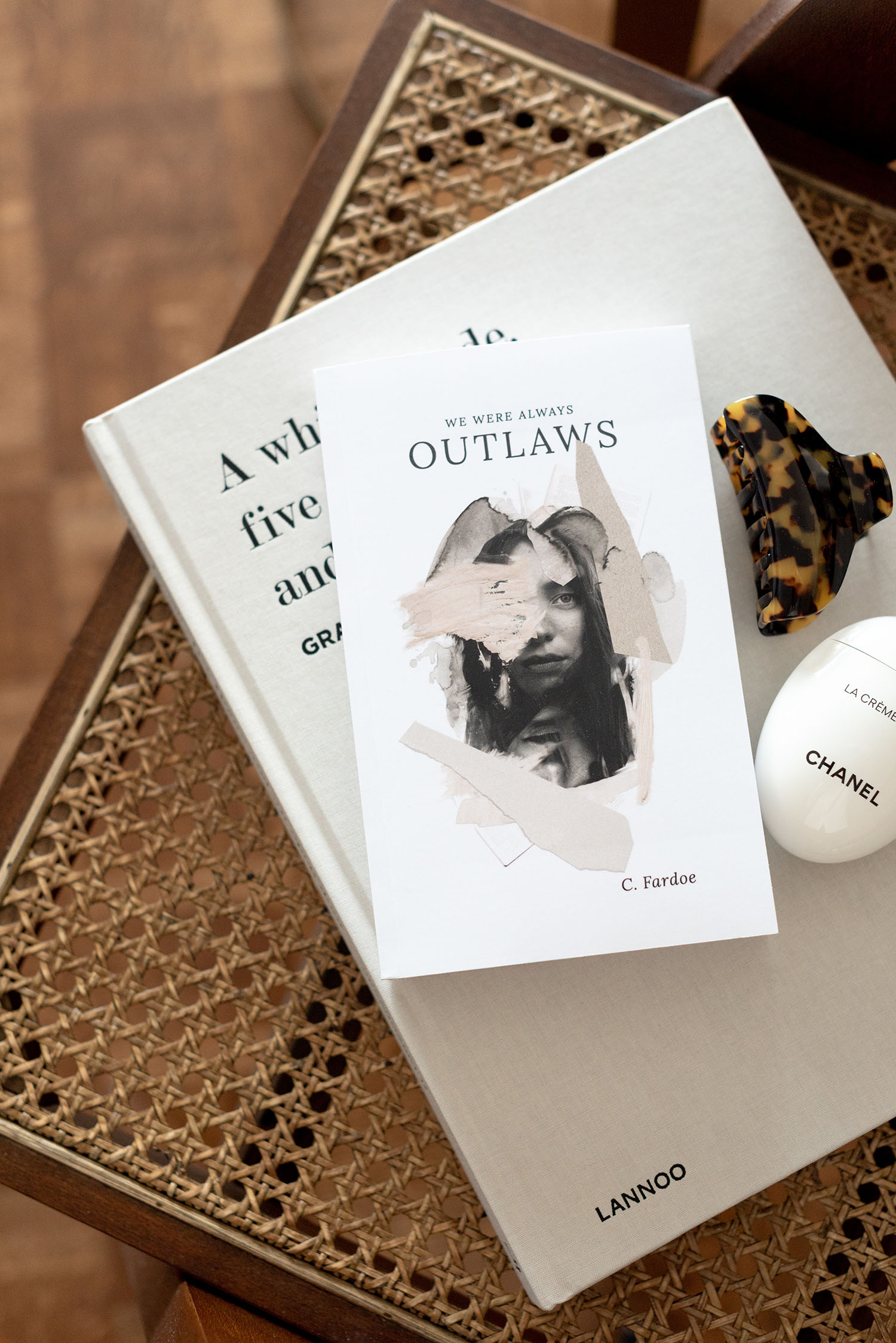 Coco & Vera - We Were Always Outlaws novel by C. Fardoe on rattan chair next to Chelsea King tortoise hair claw
