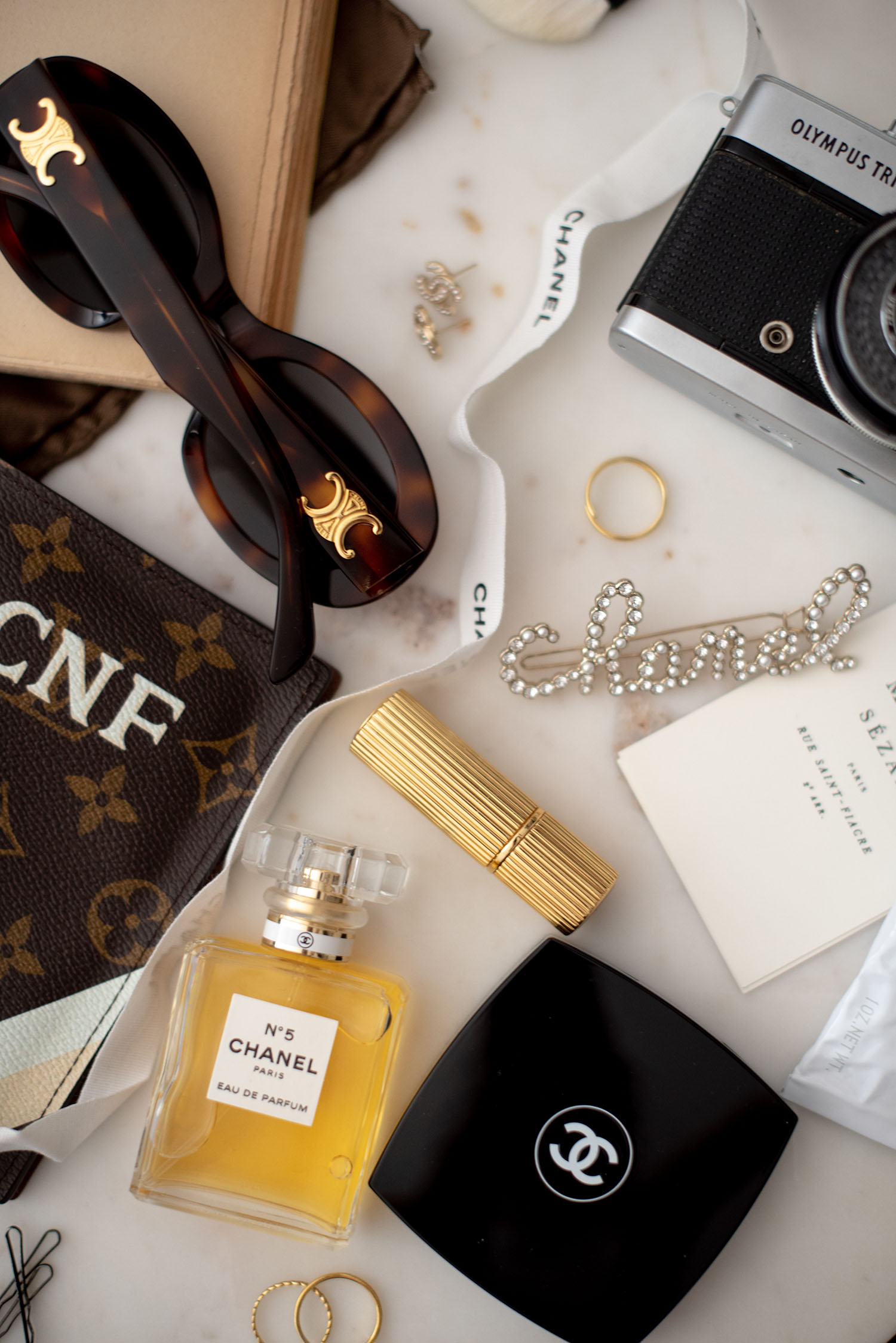 Coco & Voltaire - Celine Triomphe sunglasses, Louis Vuitton passport holder, Chanel Number 5 perfume