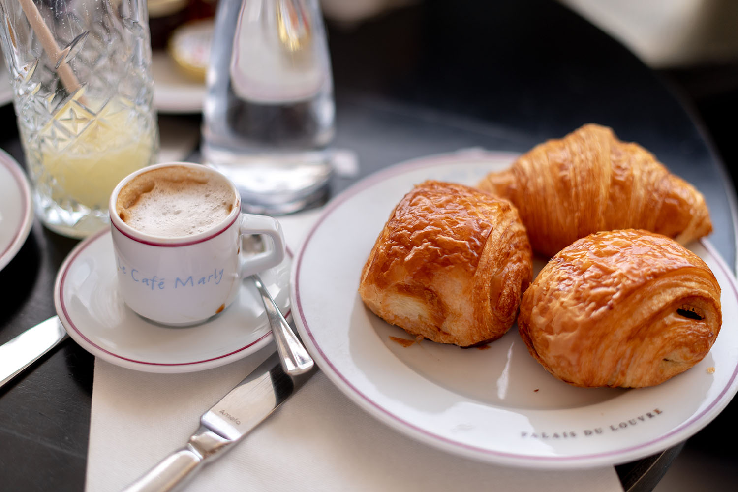Coco & Voltaire - Viennoiseries on a Cafe Marly plate next to a Cafe Marly espresso cup filled with coffee
