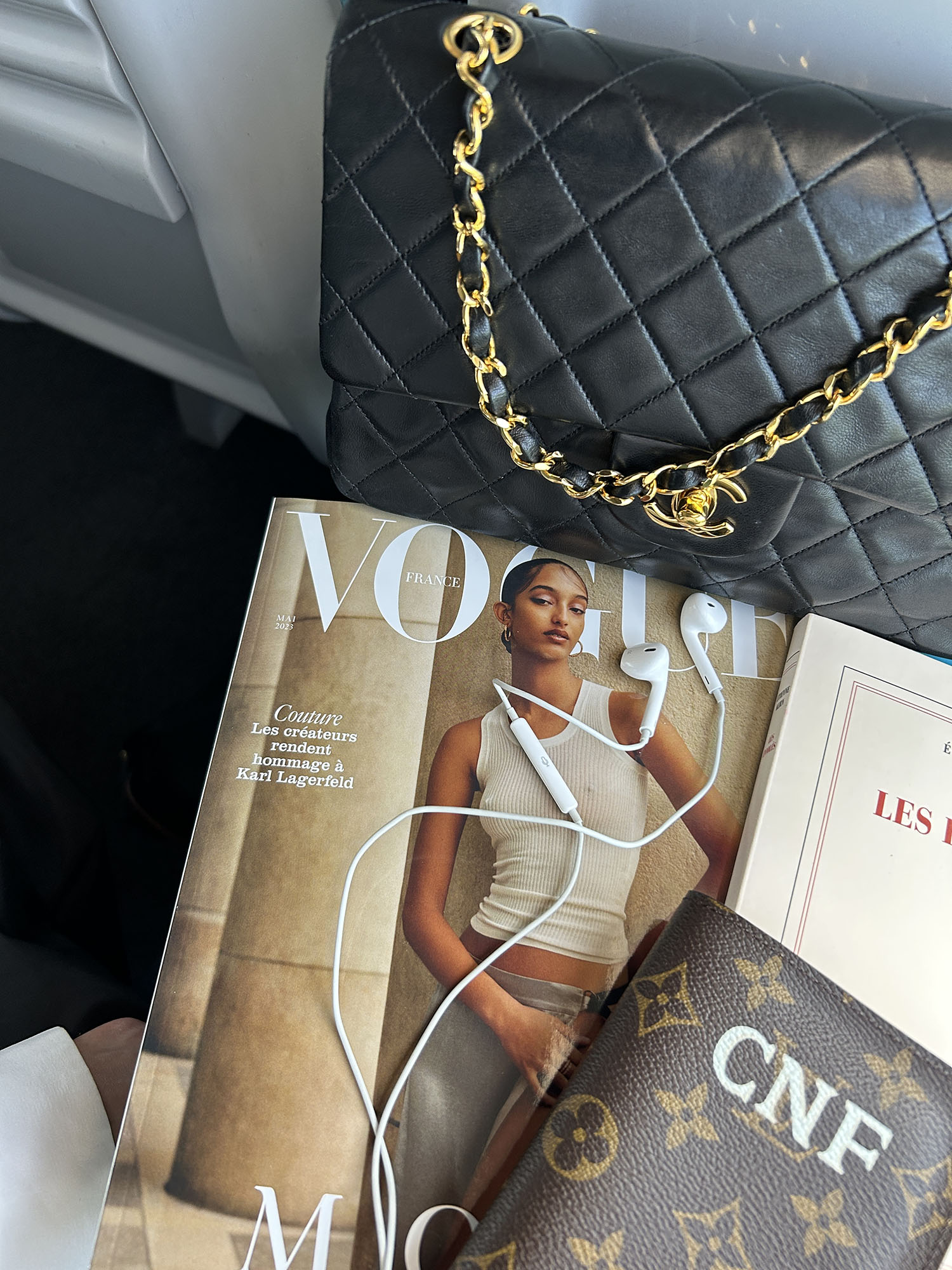 Coco & Voltaire - Vogue France, Louis Vuitton passport holder and Chanel handbag on train