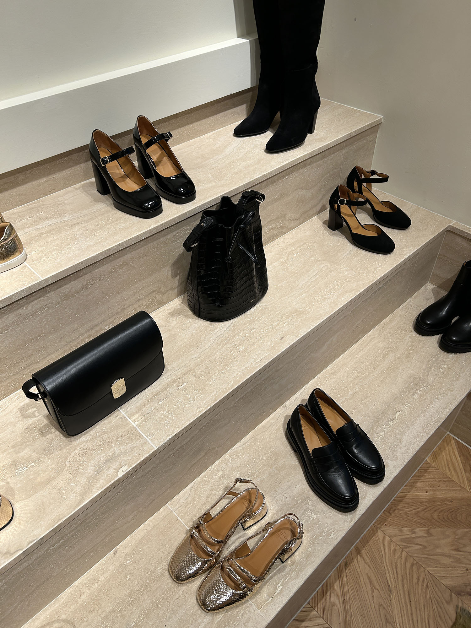 Coco & Voltaire - Black shoes and purses displayed on a marble shelf at Sezane in Marleybone, London